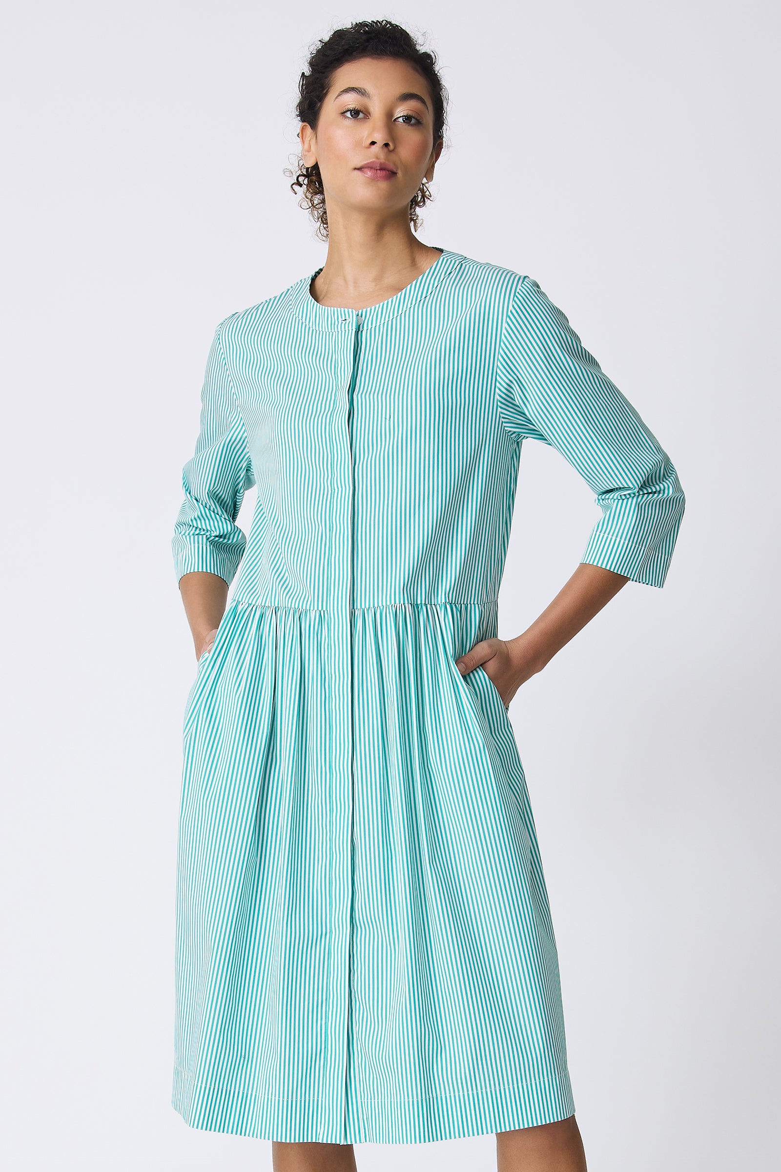 Kal Rieman Abby Shirt Dress in Miami Stripe Green on model with hands in pockets front view