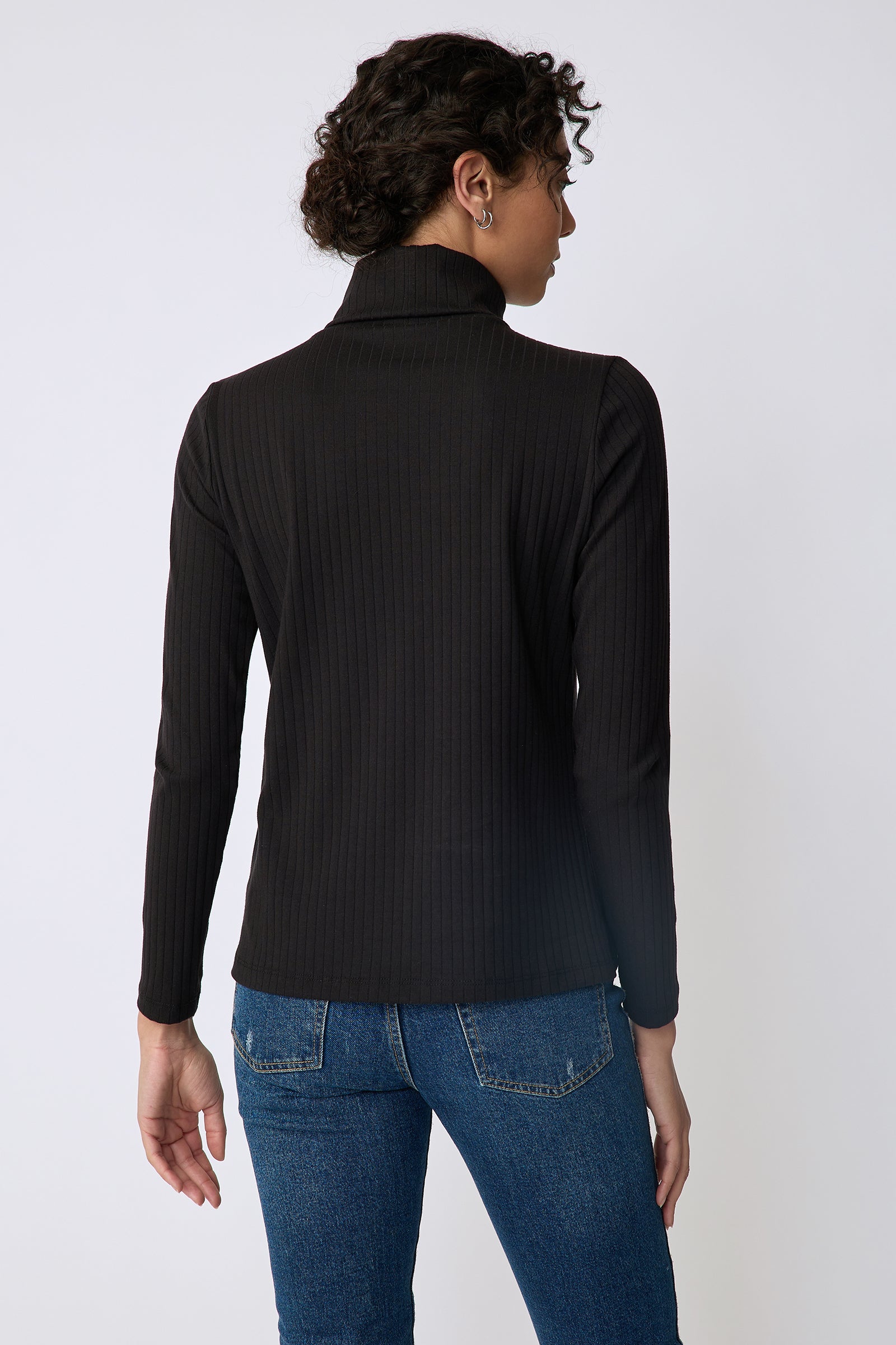 Kal Rieman Alma Rib knit tneck in black on front view full length hands in back pockets