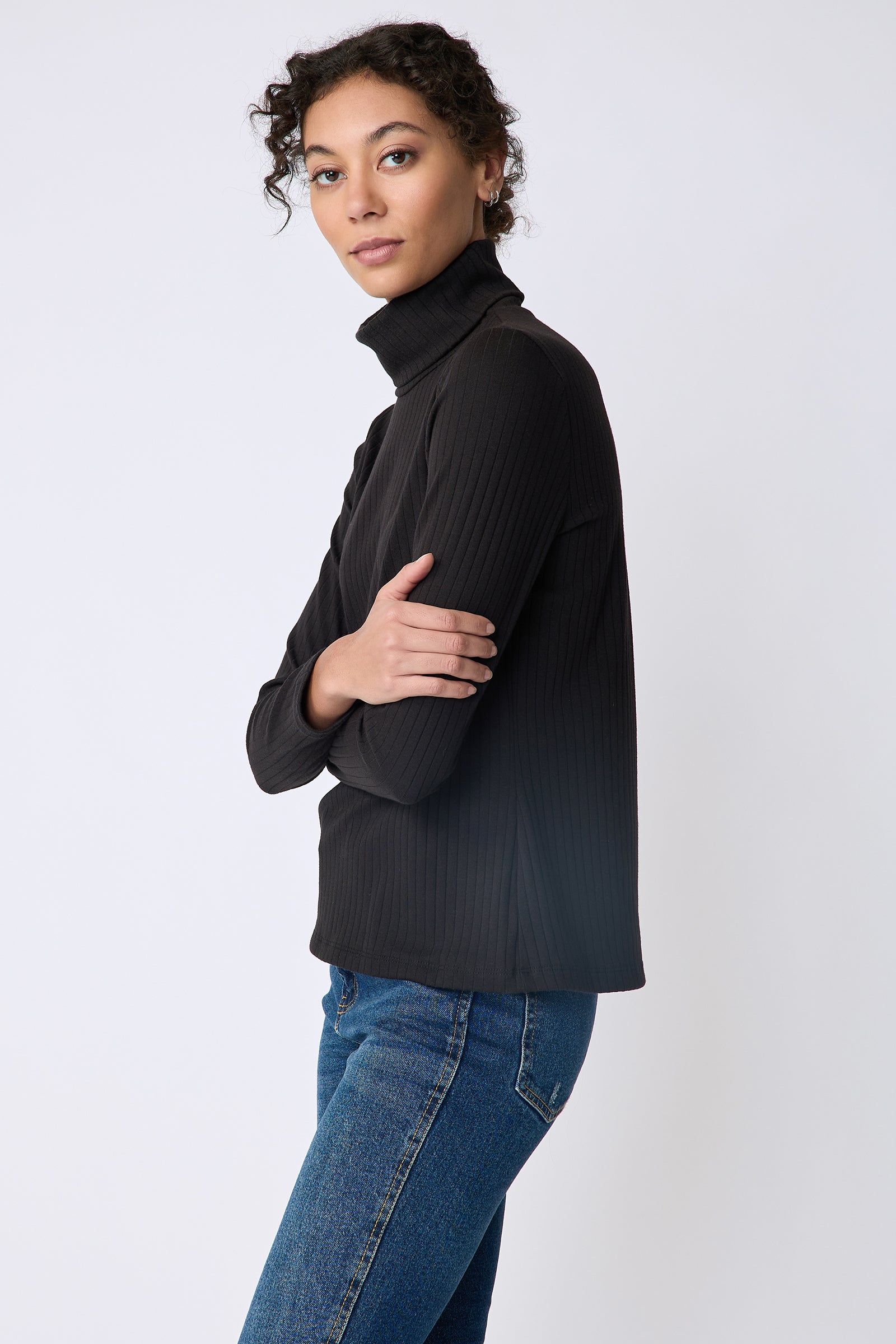 Kal Rieman Alma Rib knit tneck in black on model side view hands in front