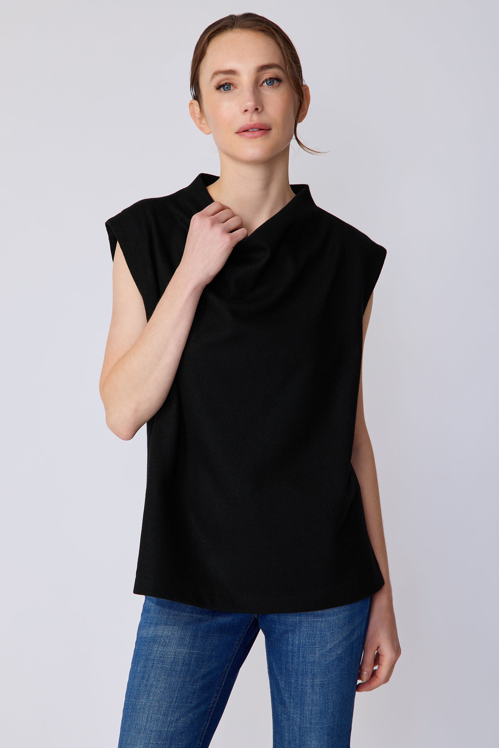 Woman wearing Kal Rieman Arla Drape Top in Black Felted Jersey with blue jeans, holding collar, close view