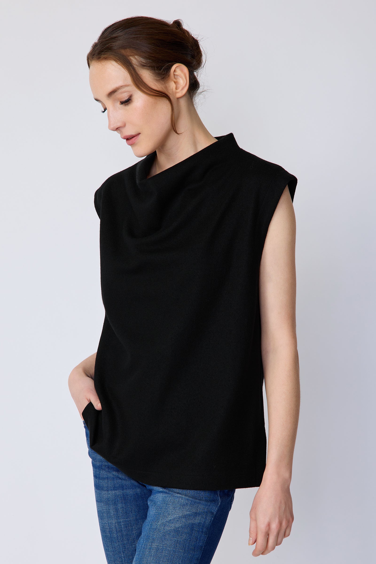 Woman wearing Kal Rieman Arla Drape Top in Black Felted Jersey with blue jeans, arm on the side, hand in pant pocket, looking down close view