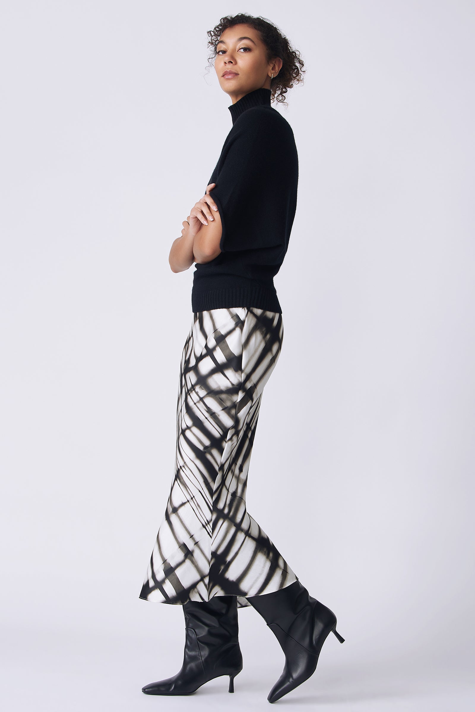 Kal Rieman Bias silk skirt in watercolor print on model side view walking arms crossed in front