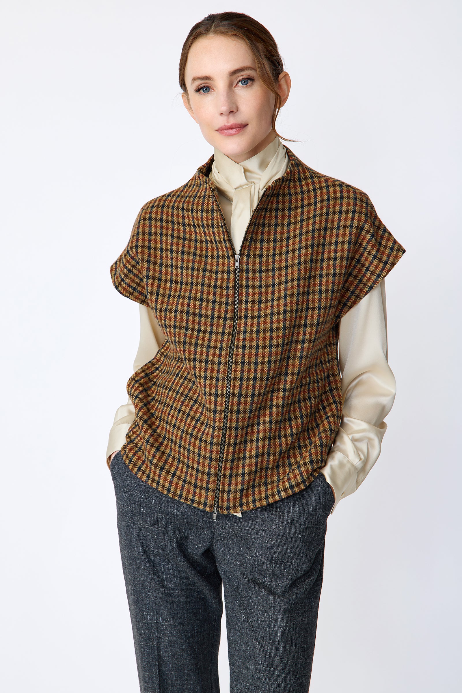 Woman wearing Kal Rieman Bruna Zip Vest in Heritage Check over a Kal Rieman Silk Regency Blouse in Oyster with a white background, hands in pocket