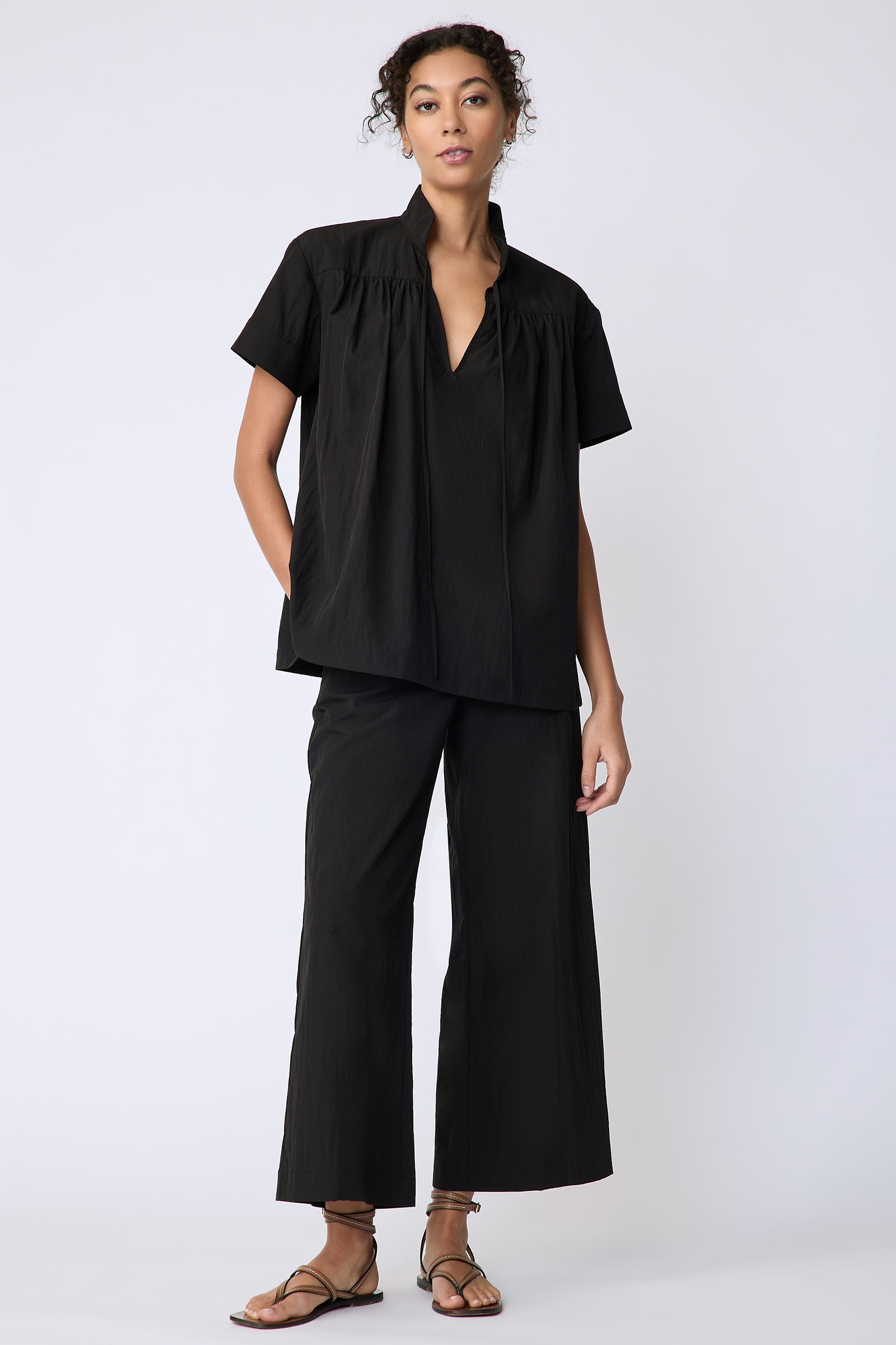 Kal Rieman Camille Top in black typewriter cloth on model front view hands in pockets full length