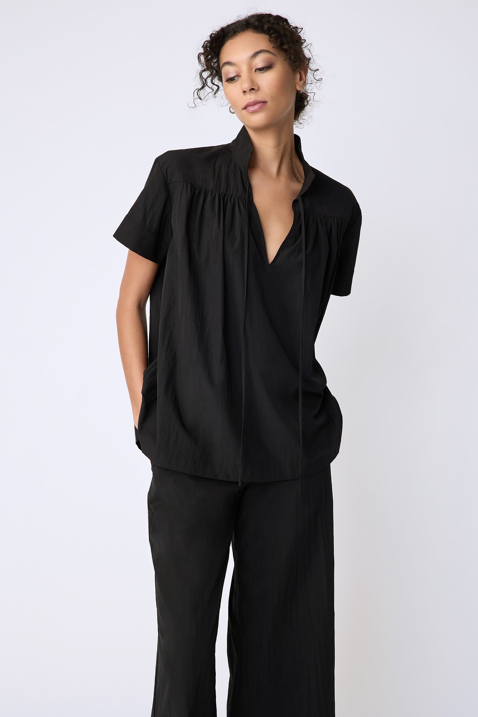 Kal Rieman Camille Top in black typewriter cloth on model front view hands in pockets