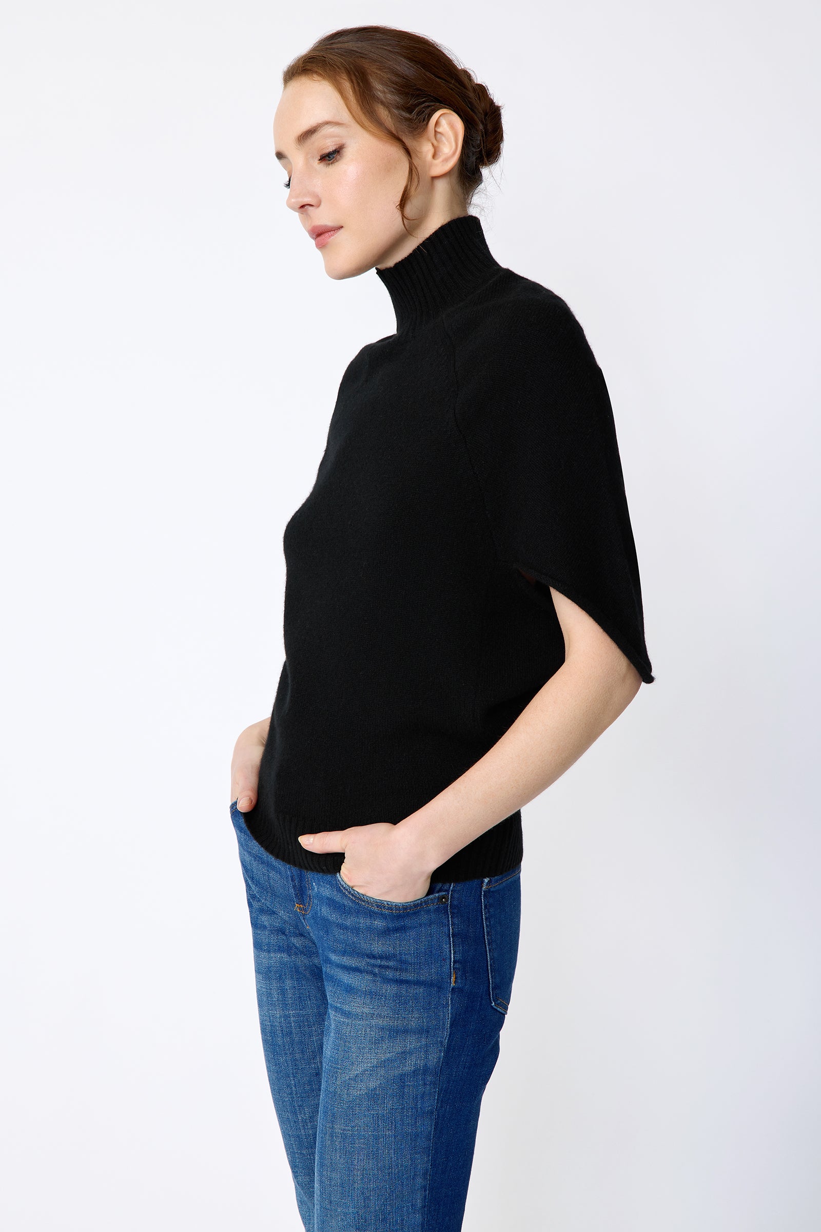 Kal Rieman Cashmere Cape Sweater in black on model side view hands in pockets