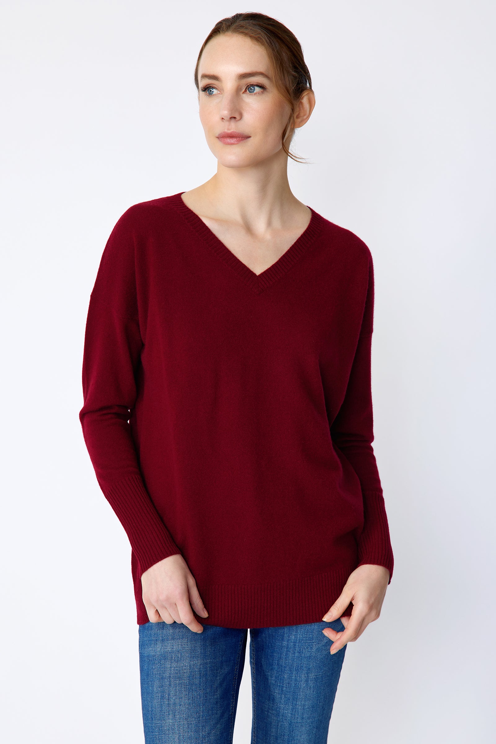 Kal Rieman Cashmere Vneck in bordeaux on model front view holding hem