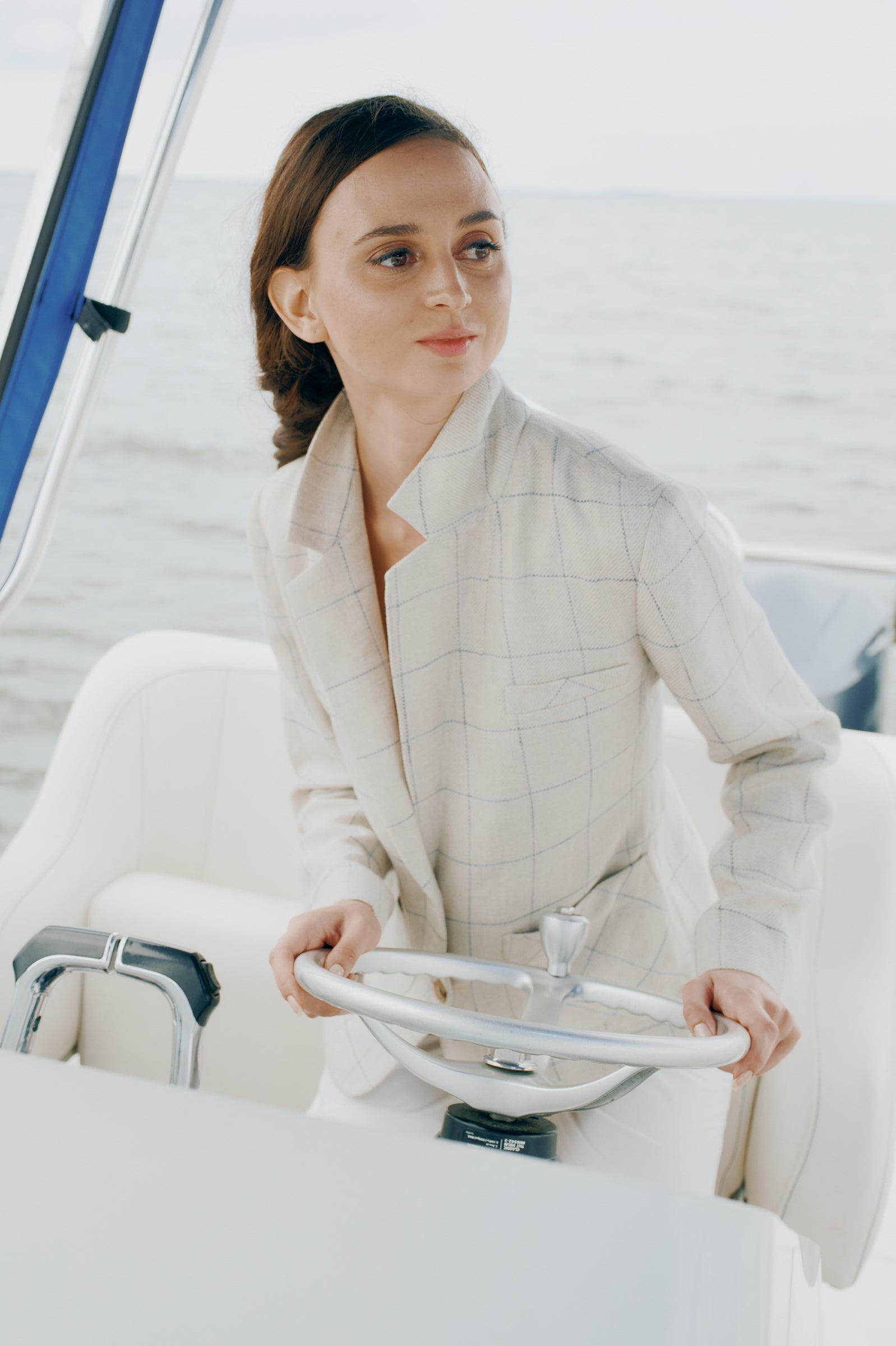 Kal Rieman Castel Patch Pocket Blazer in Windowpane on model driving a boat