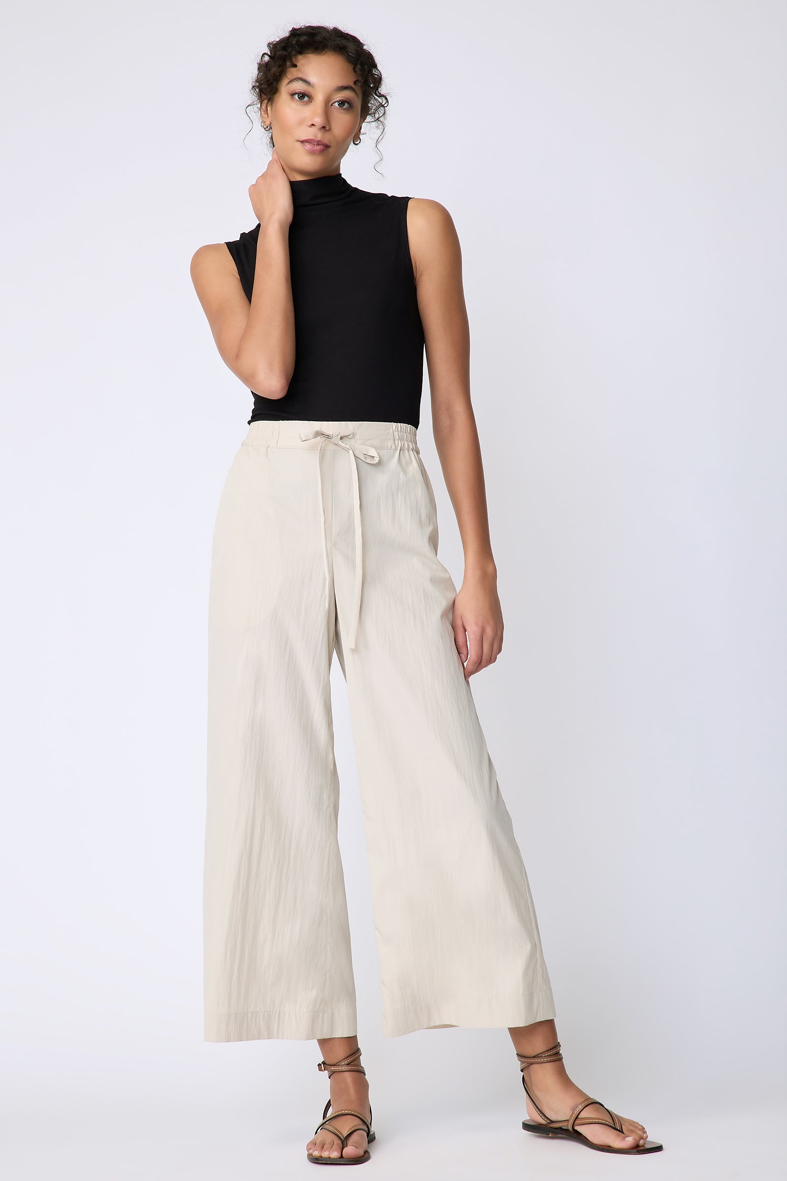 Kal Rieman Celeste Pant in khaki typewriter cloth on model front hand on face