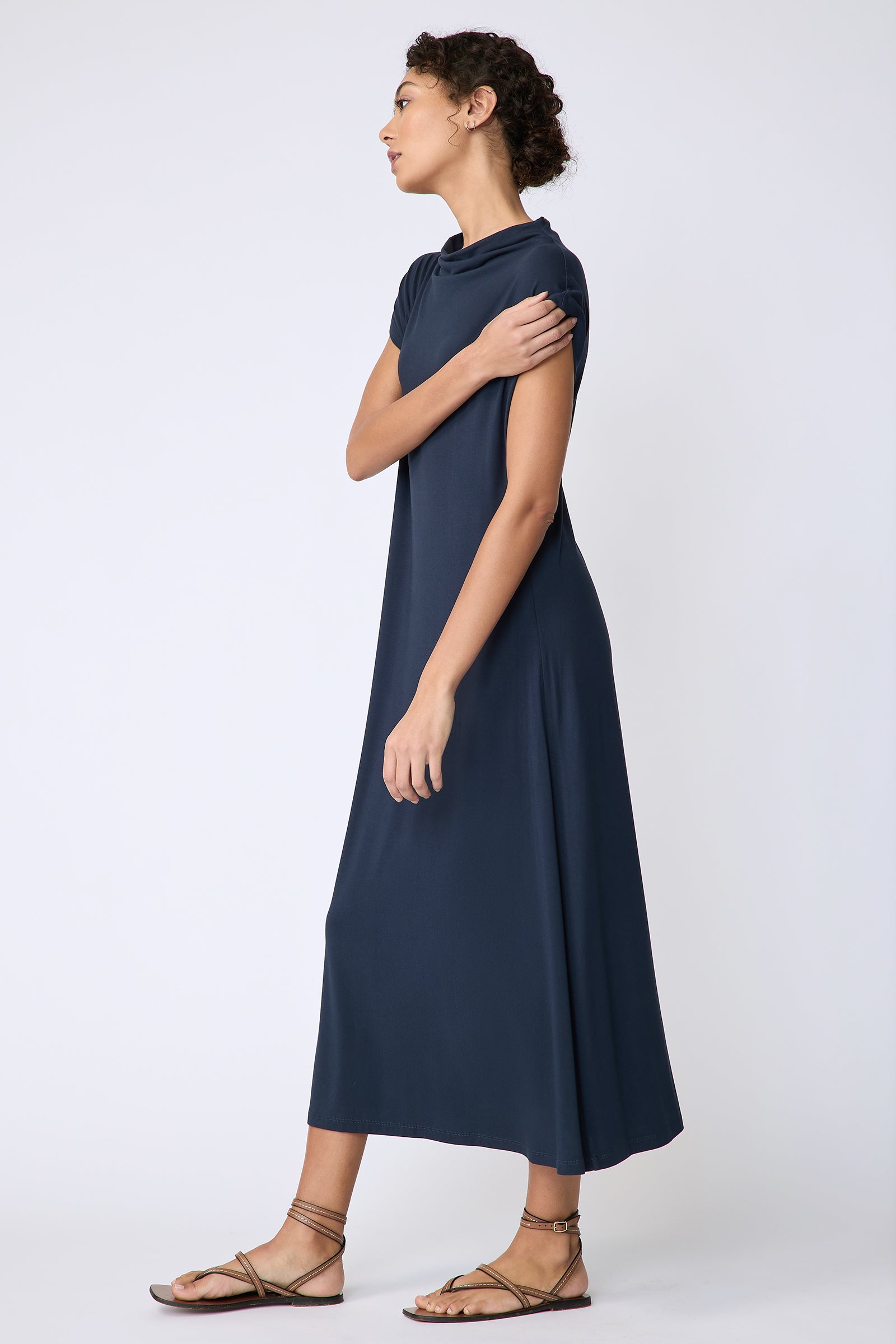Kal Rieman Christie Knit dress in navy bamboo jersey on model side view holding sleeve