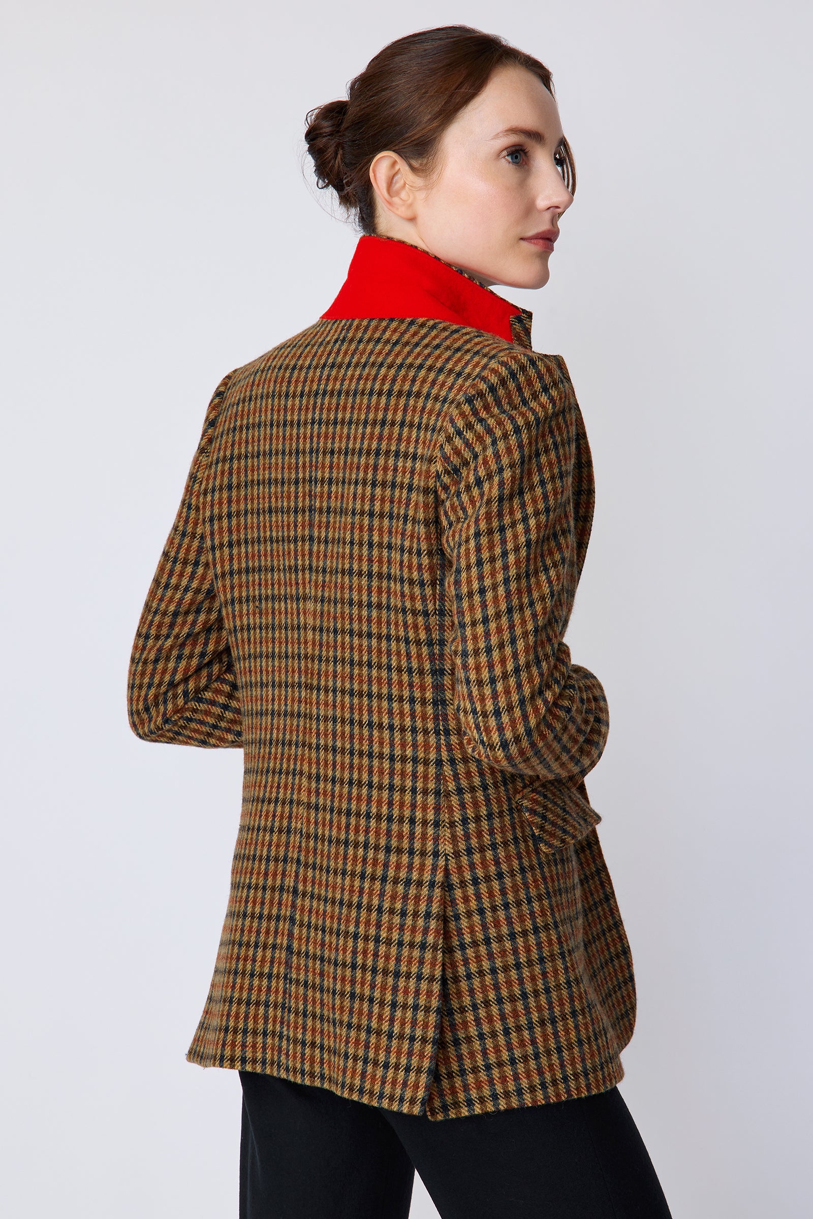 Woman wearing Kal Rieman Classic Tailored Blazer in Heritage Check with black pants, arms on the front, back view
