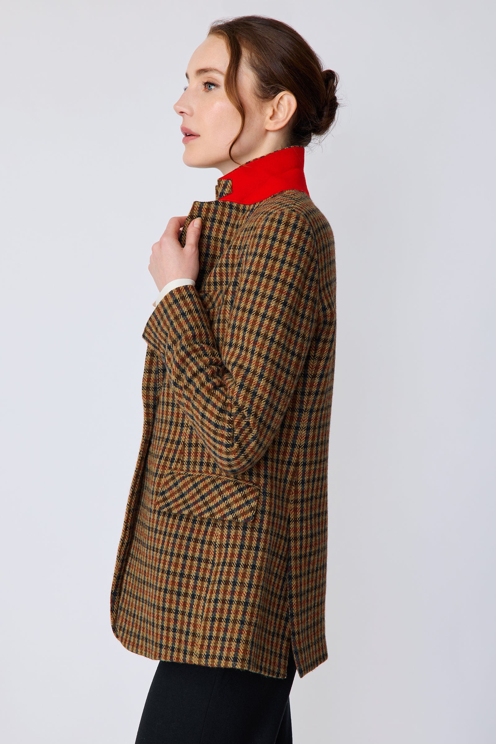 Woman wearing Kal Rieman Classic Tailored Blazer in Heritage Check over Kal Rieman Cecilia Scarf Top in Ivory with black pants, holding blazer collar, side view