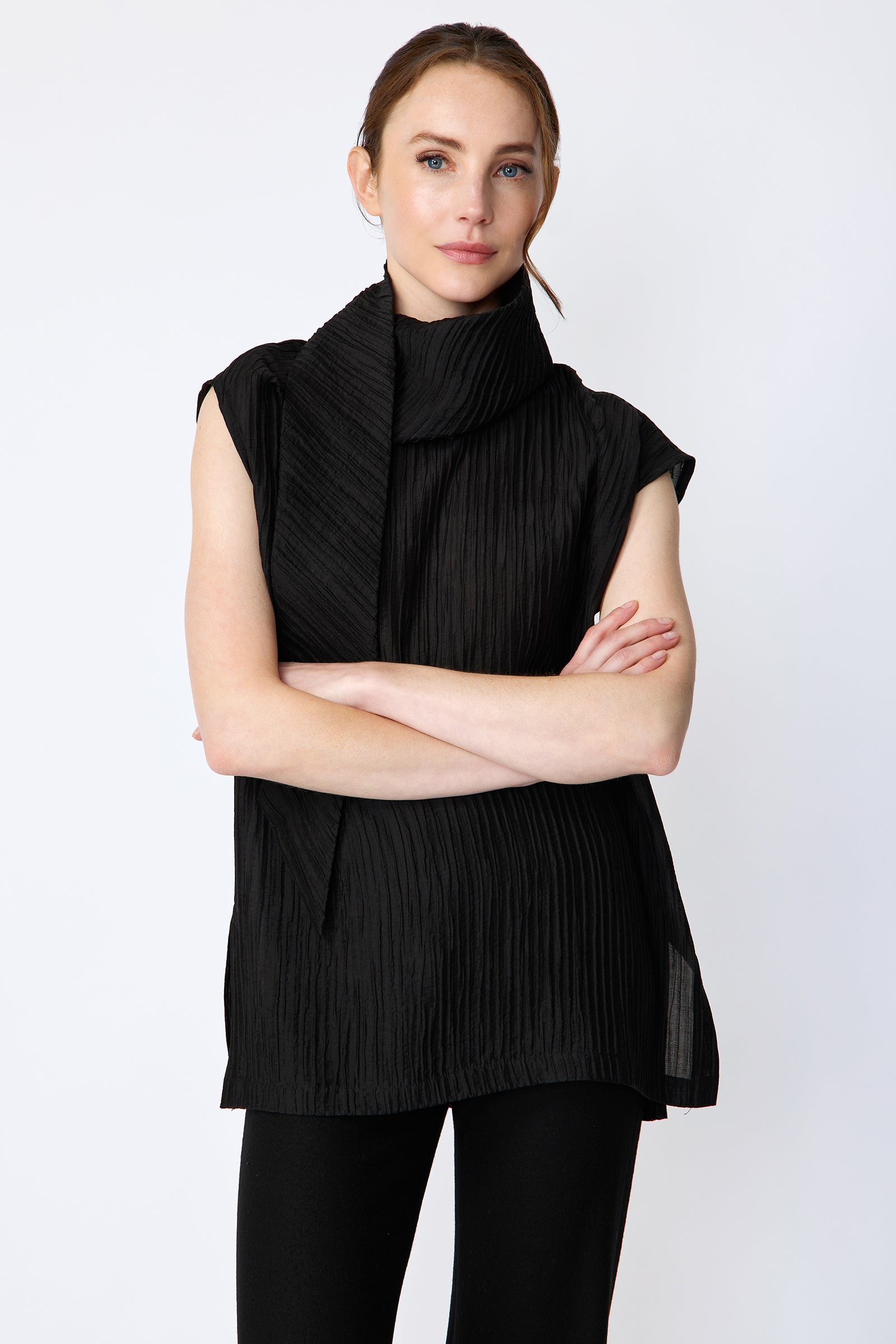 Woman wearing Kal Rieman Claudia Scarf Tunic in Black Taffeta on a white background, arms crossed in the front, close view