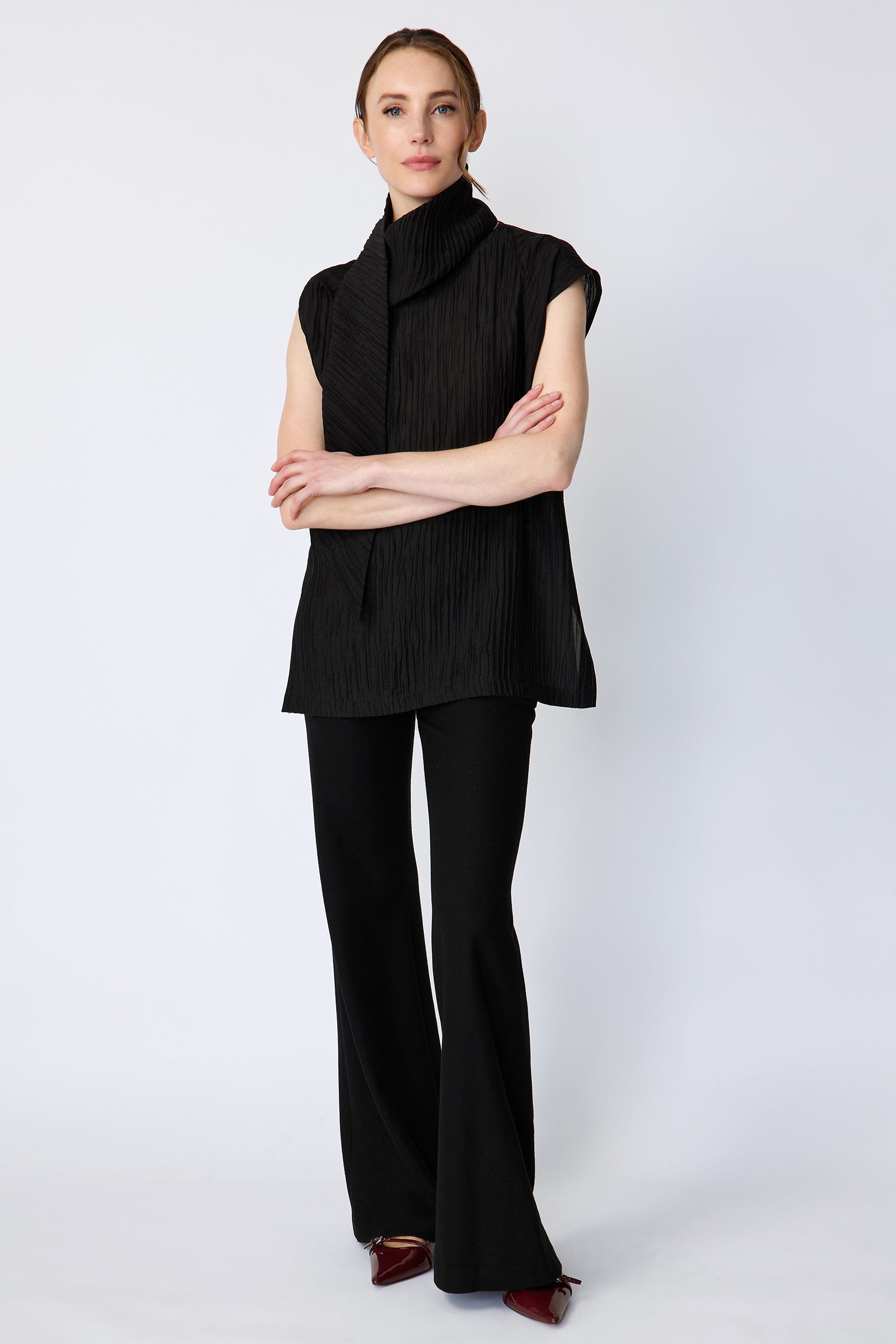 Woman wearing Kal Rieman Claudia Scarf Tunic in Black Taffeta on a white background, arms crossed in front