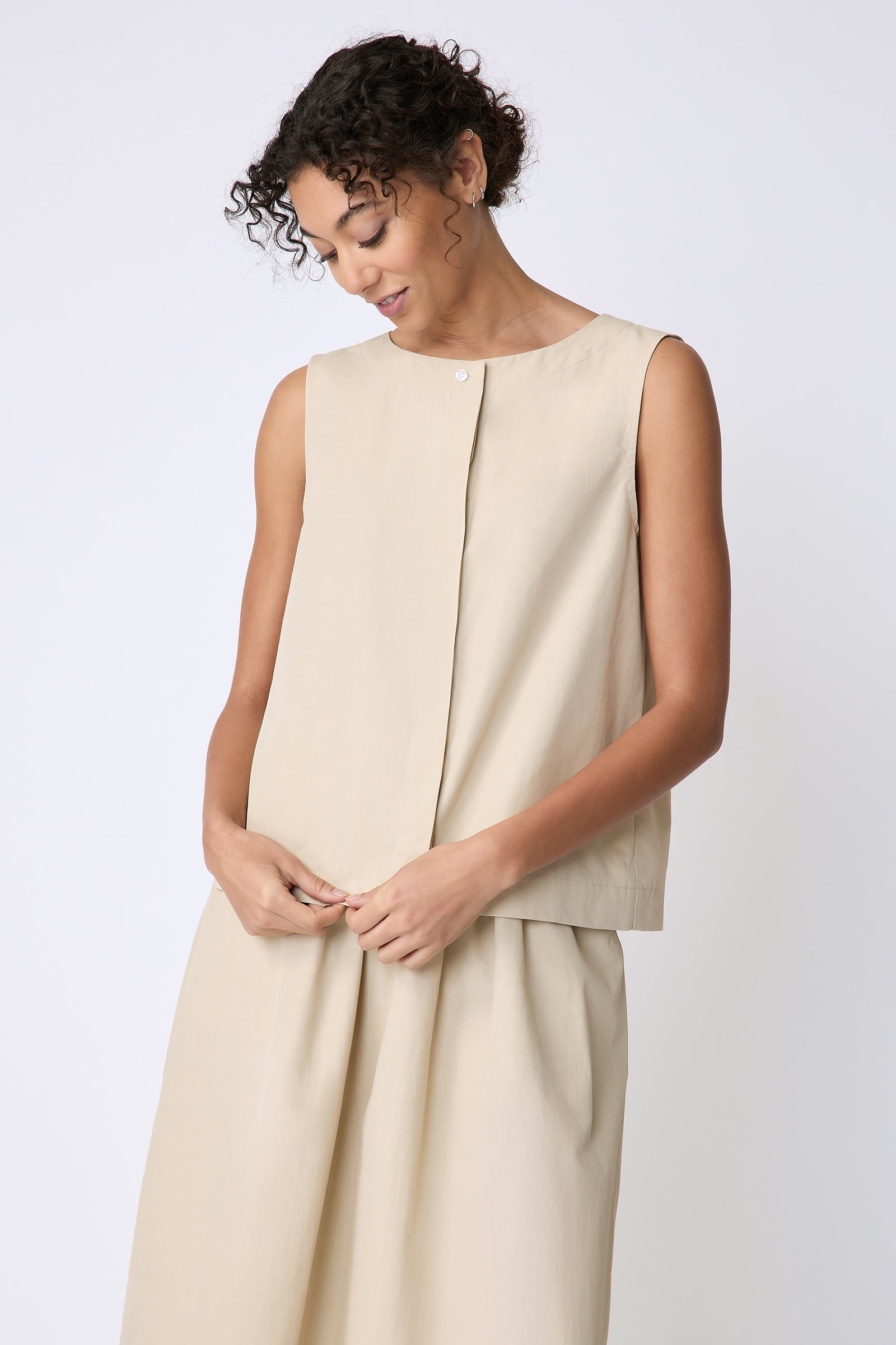 Kal Rieman Colette Shell in Italian Broadcloth sand on model front view holding hem