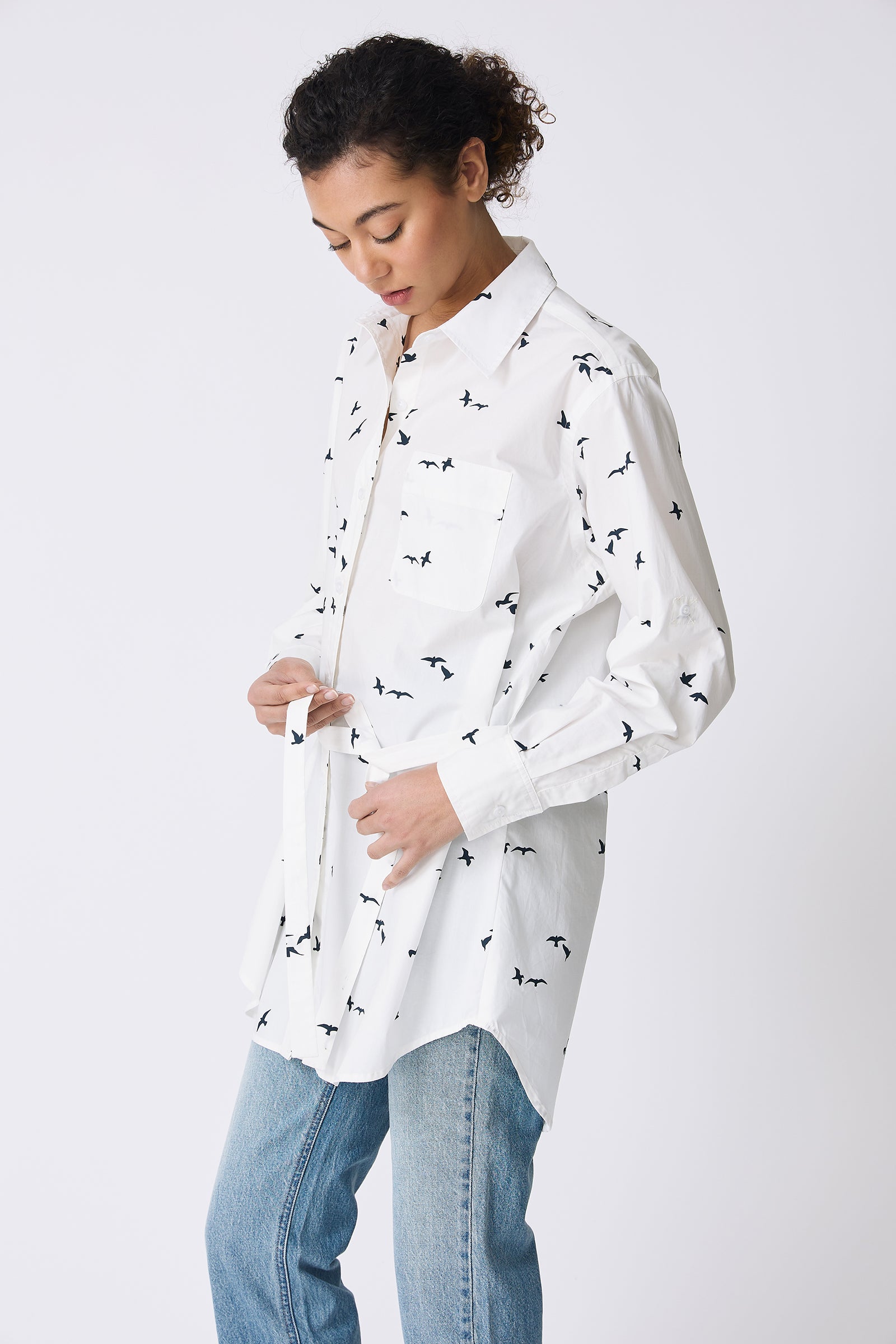 Kal Rieman Deanna Shirt in White Bird Print on model tying belt front view