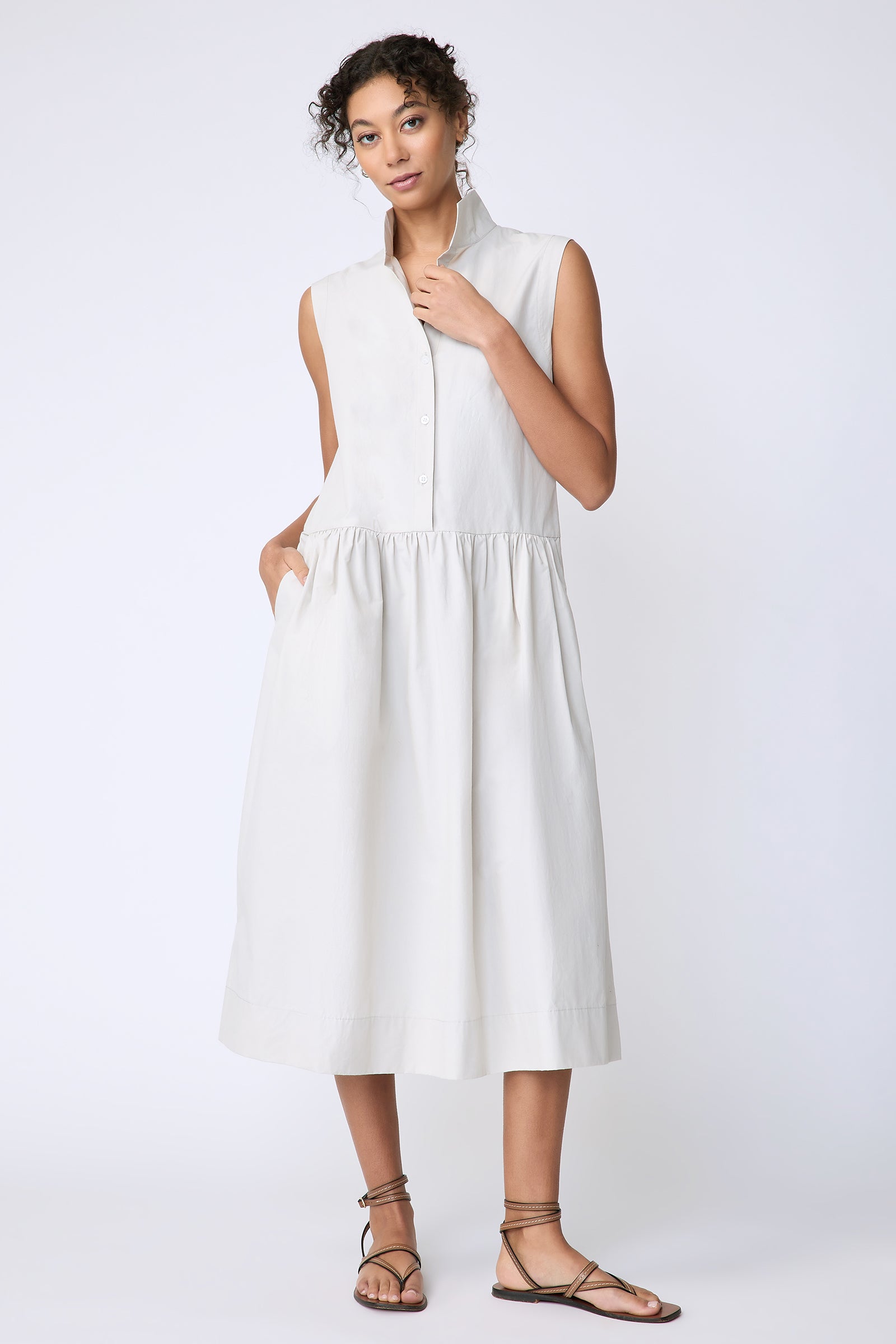 Kal Rieman Demi Dress in Italian Broadcloth stone color on model front view holding collar hand in pocket