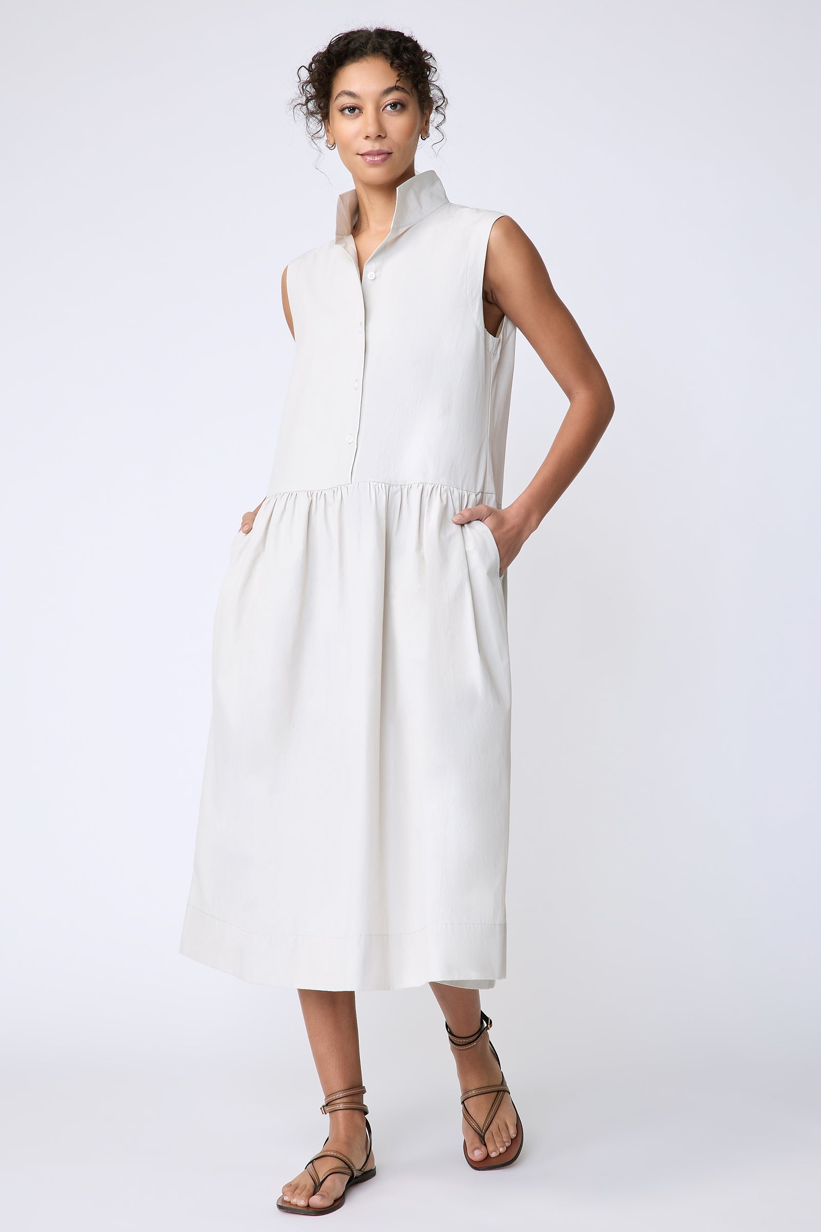 Kal Rieman Demi Dress in Italian Broadcloth stone color on model front view walking hands in pockets