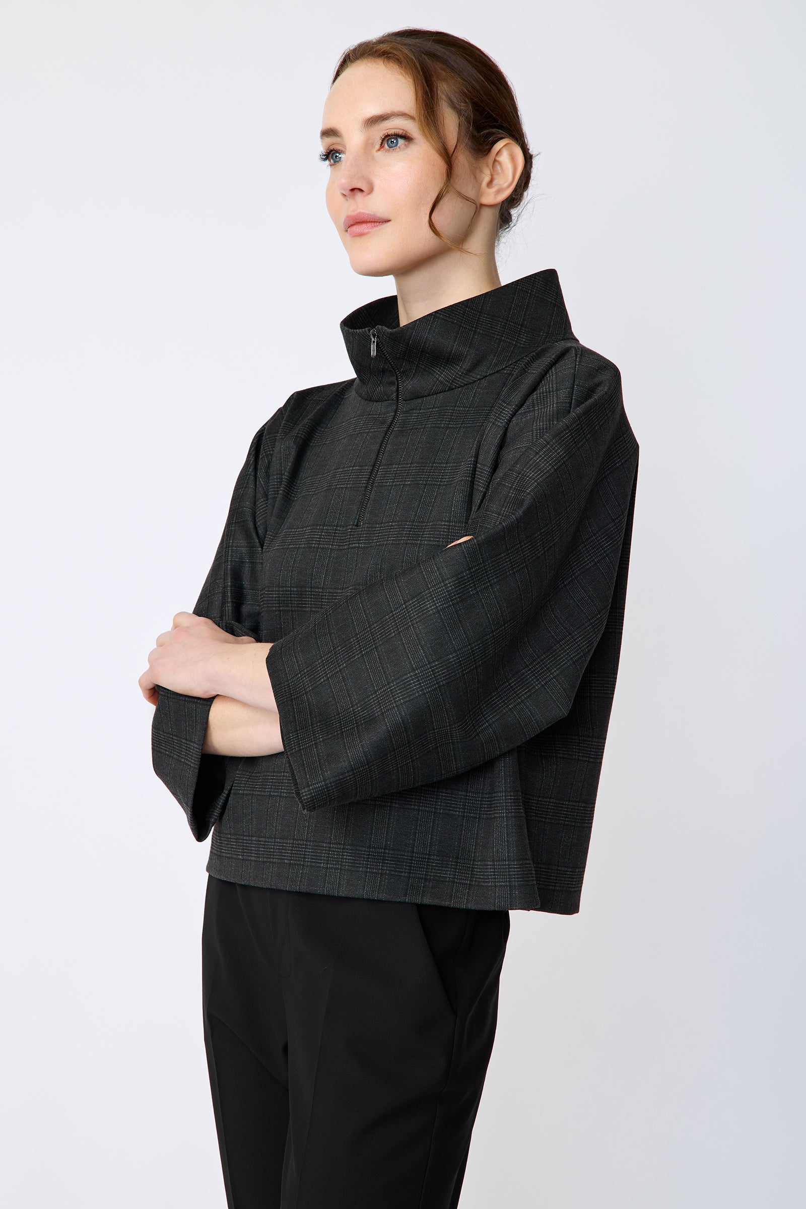 Woman wearing the Kal Rieman Edith Kimono Top in Black Glen Plaid and black pants on a white background arms crossed in the front side view
