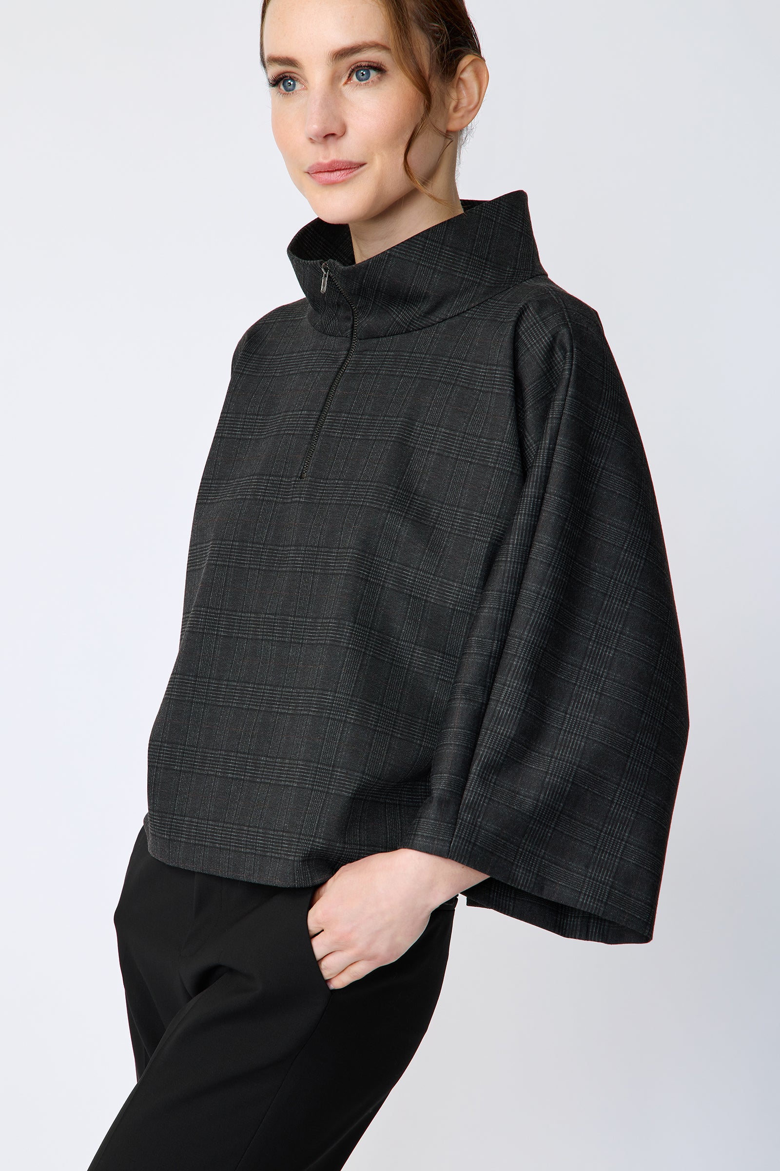 Woman wearing the Kal Rieman Edith Kimono Top in Black Glen Plaid and black pants on a white background arm in pocket close up view