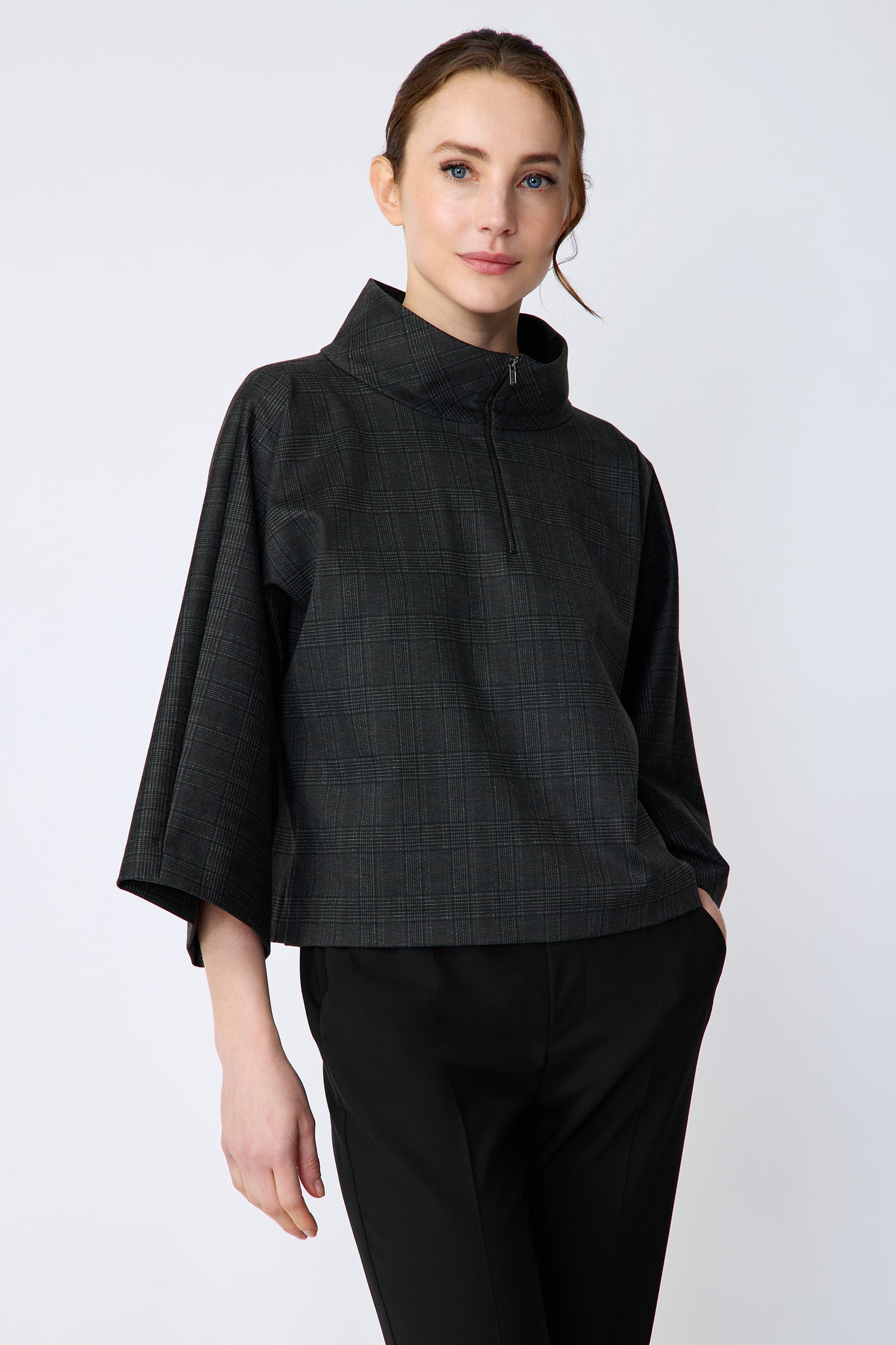 Woman wearing the Kal Rieman Edith Kimono Top in Black Glen Plaid and black pants on a white background hand in pocket