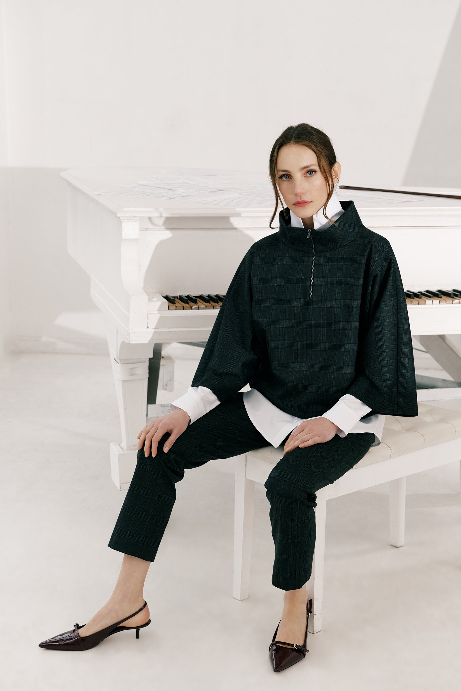 Woman wearing the Kal Rieman Edith Kimono Top in Black Glen Plaid and black pants on a white background hand in pocket