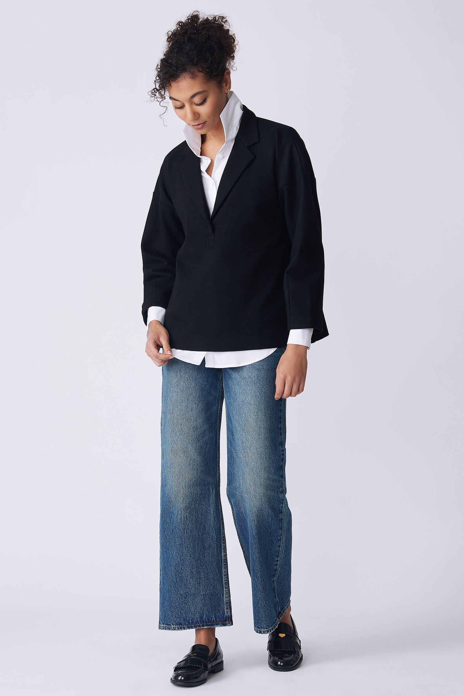 Kal Rieman Elaine Notch Placket Pullover in black Italian felted jersey on model front view walking looking down