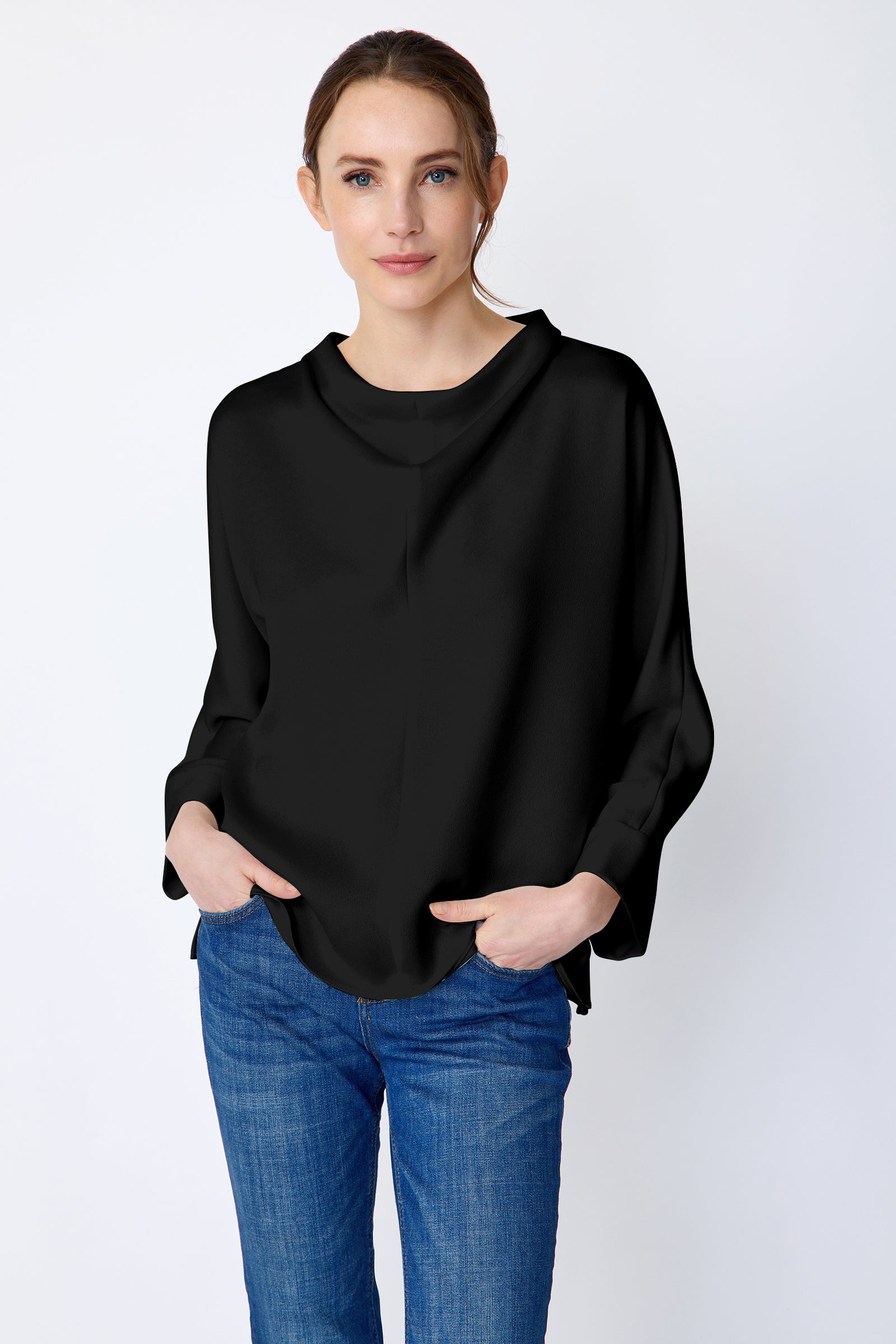 Woman wearing Kal Rieman Elena Drape Top in black satin with blue jeans, hands in pant pockets, close front view
