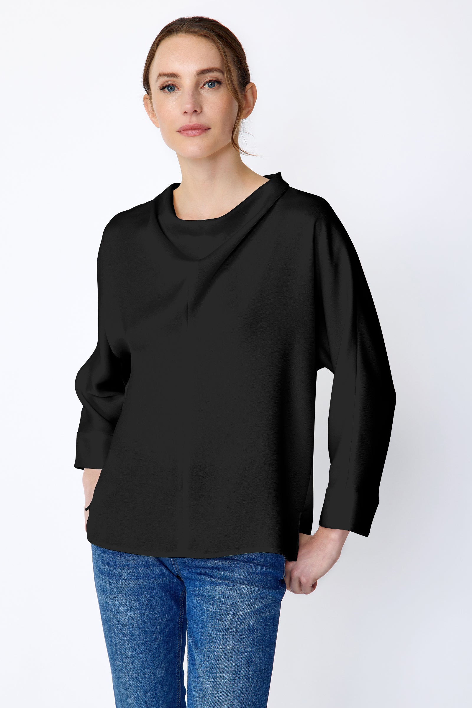 Woman wearing Kal Rieman Elena Drape Top in black satin with blue jeans, hands in pant back pockets, close front view