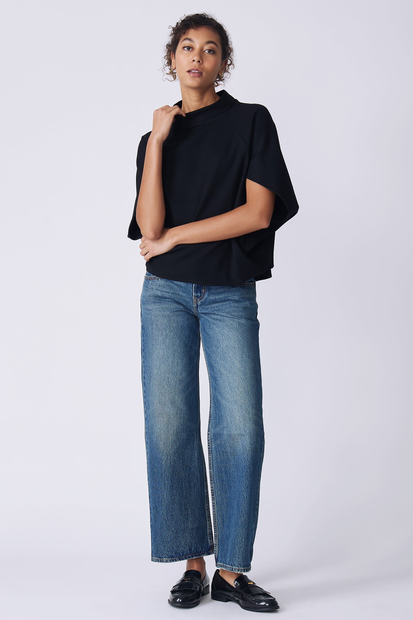 Kal Rieman Elsa Cape Top in black on model front view holding collar