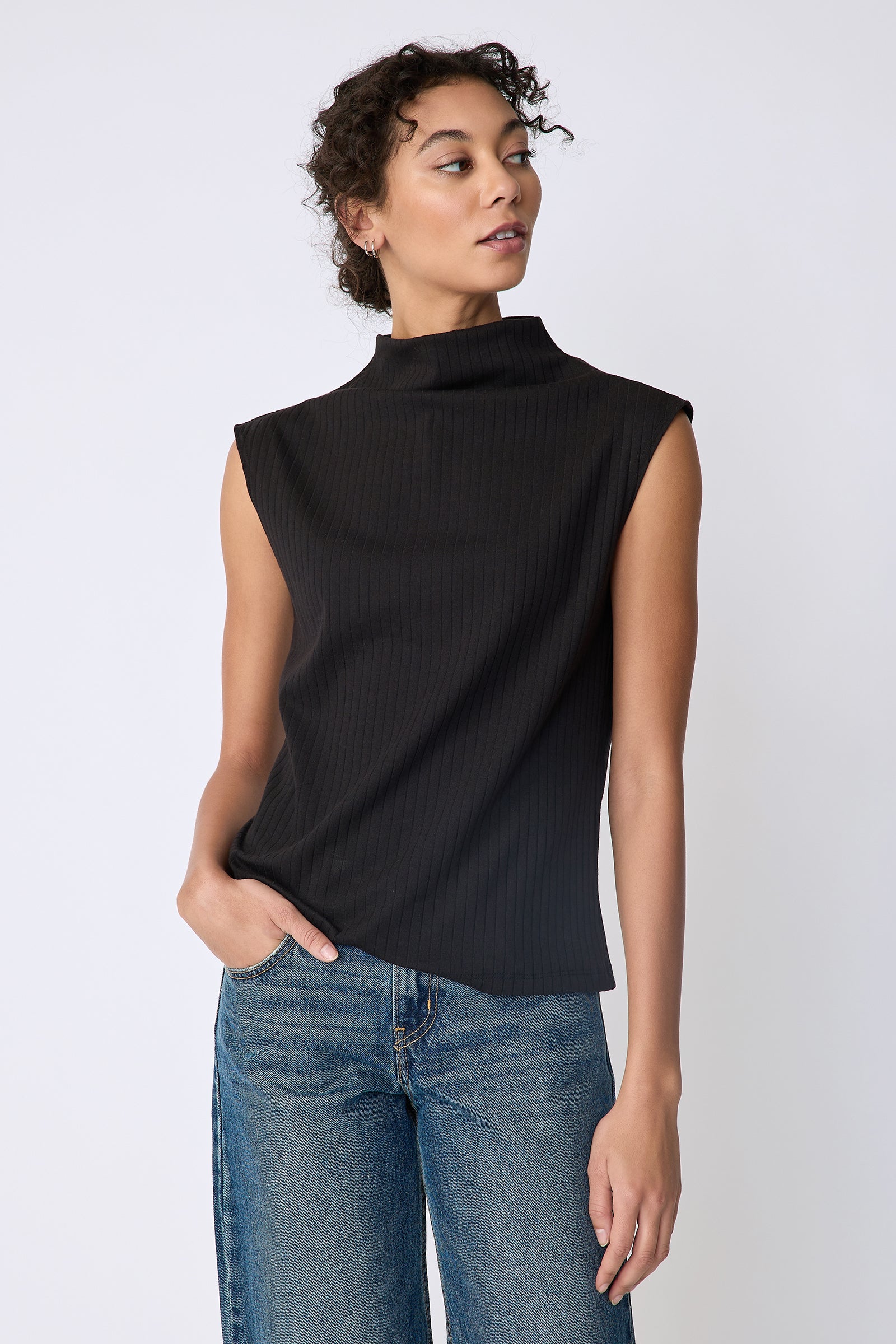Kal Rieman Eva Funnelneck top in black rib knit on model front view hand in pocket