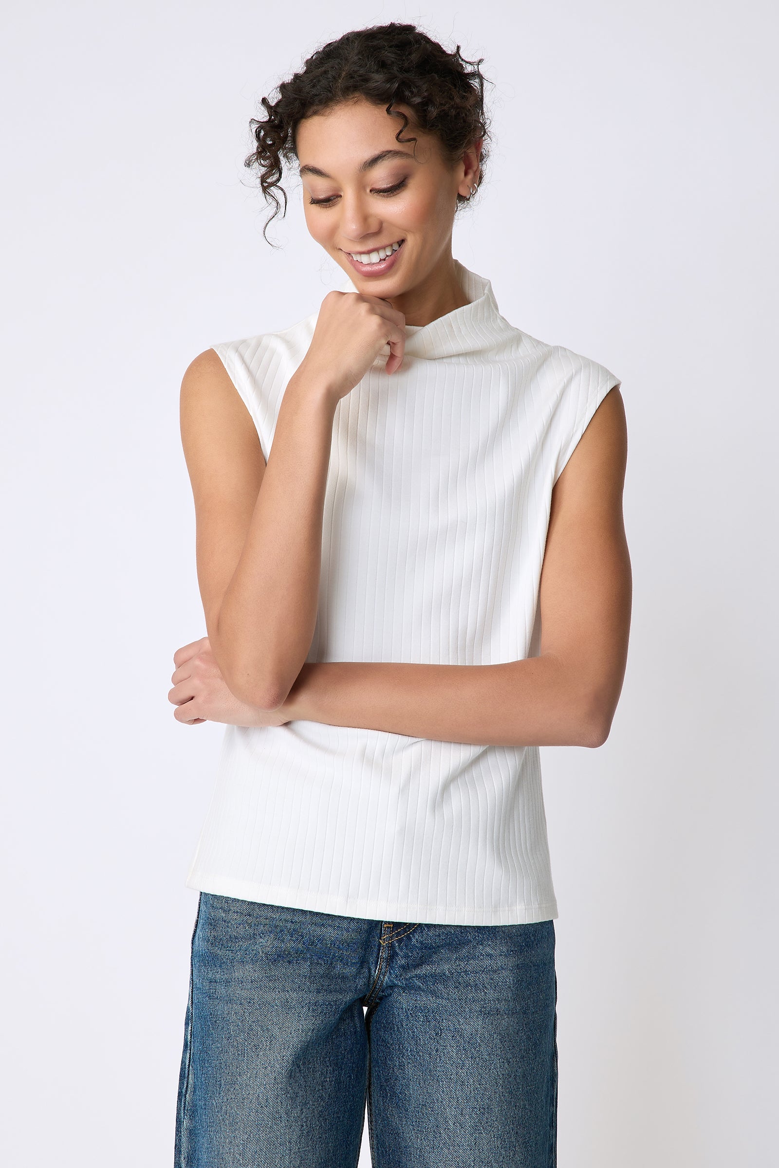 Kal Rieman Eva Funnelneck top in ivory rib knit on model front view hand on cheek
