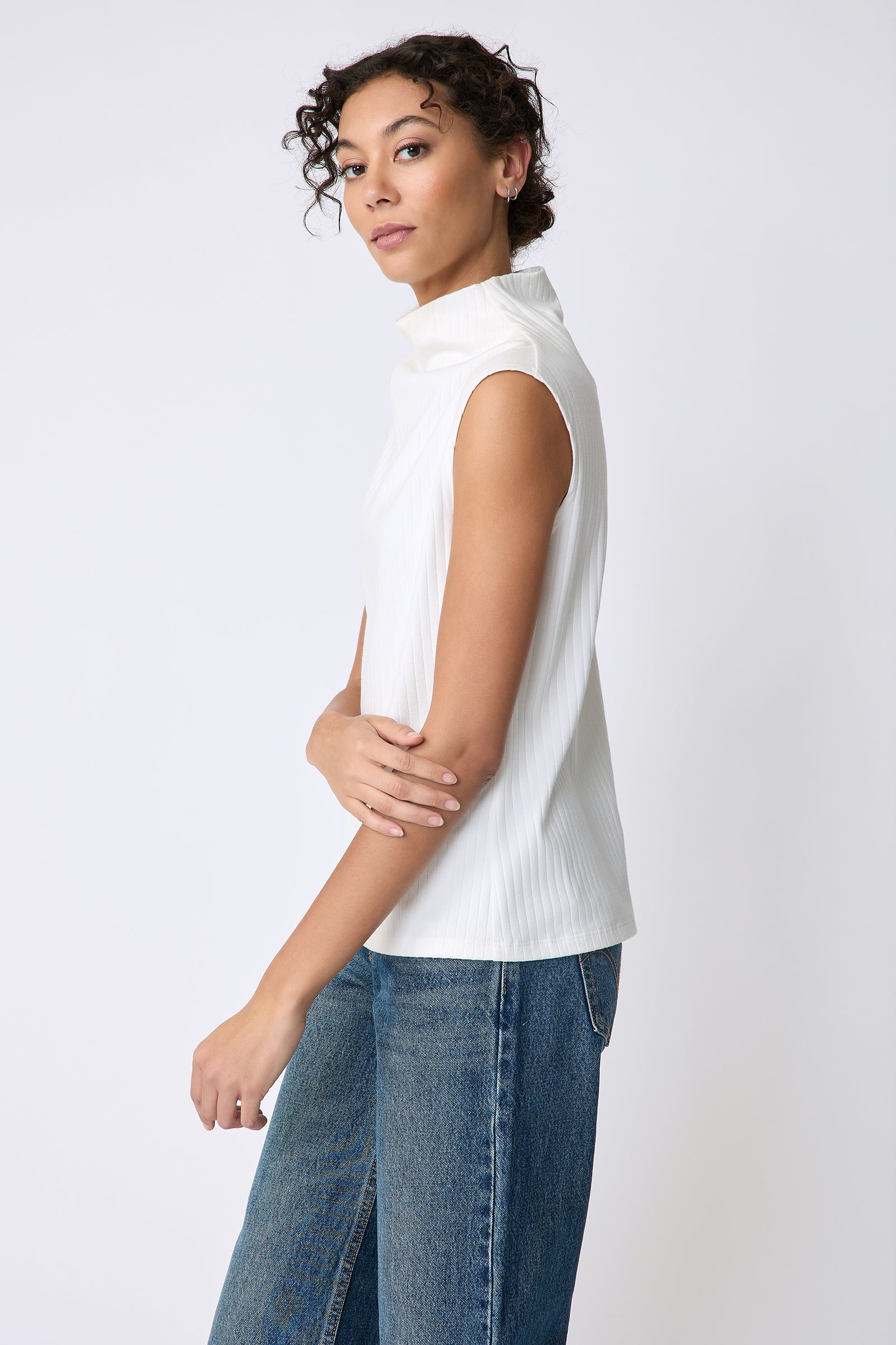 Kal Rieman Eva Funnelneck top in ivory rib knit on model side view holding elbow
