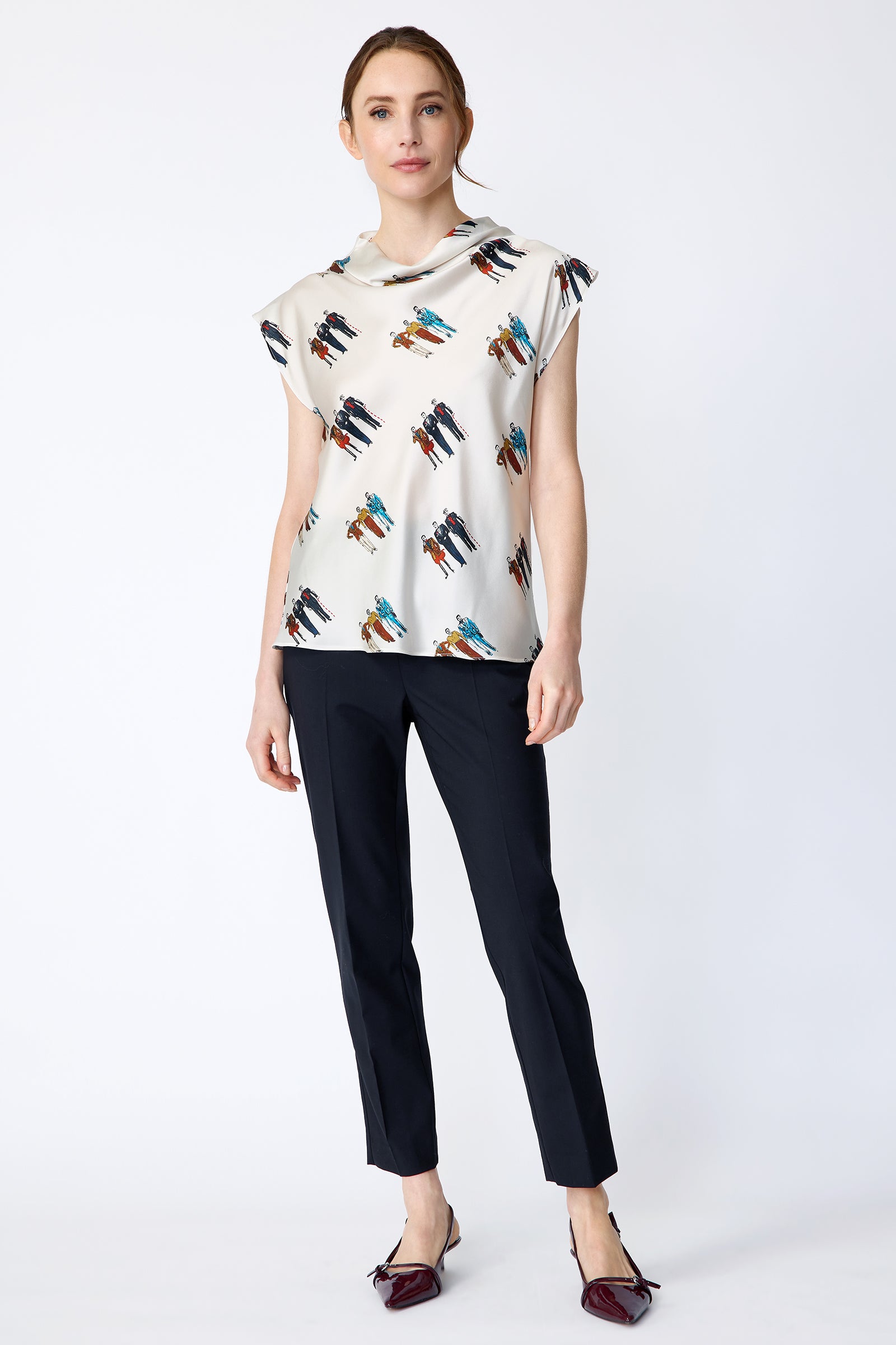 Woman wearing Kal Rieman Gloria Drape Top in Dandy Print and black pants on a white background