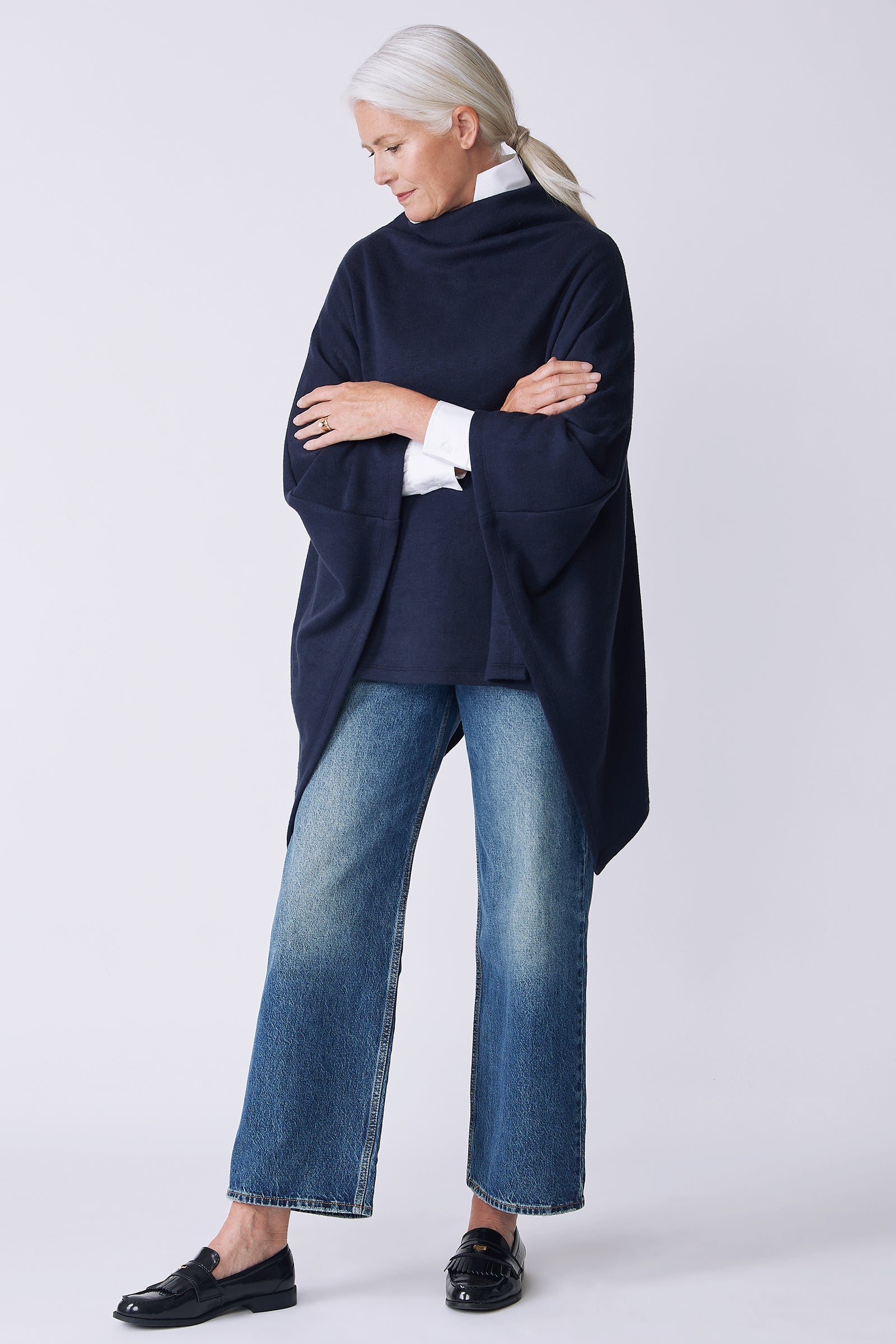 Kal Rieman Jackie Cape in blue knit on model side view arms crossed