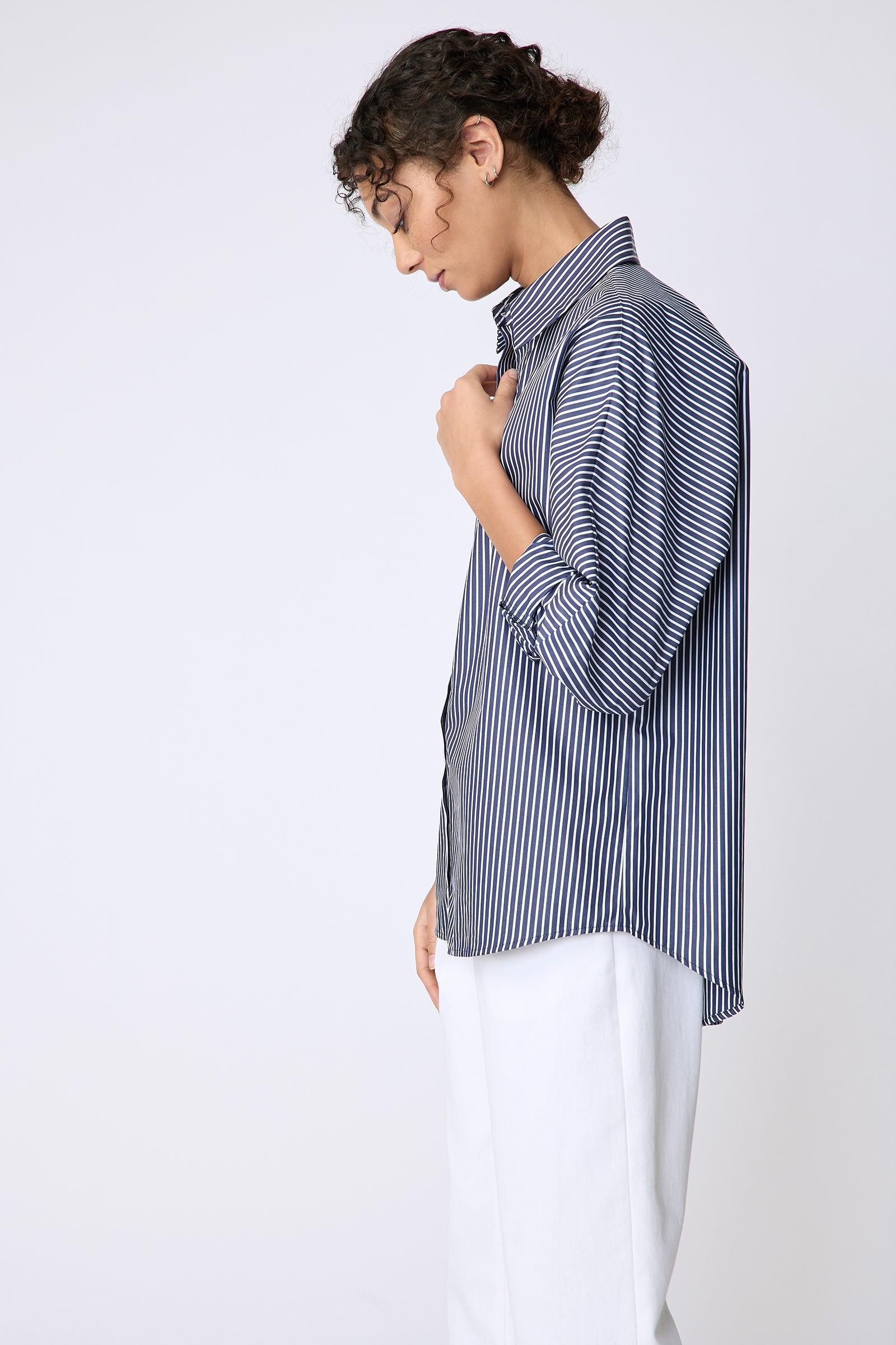 Kal Rieman Lauren Blouse in savoy stripe on model side view holding placket