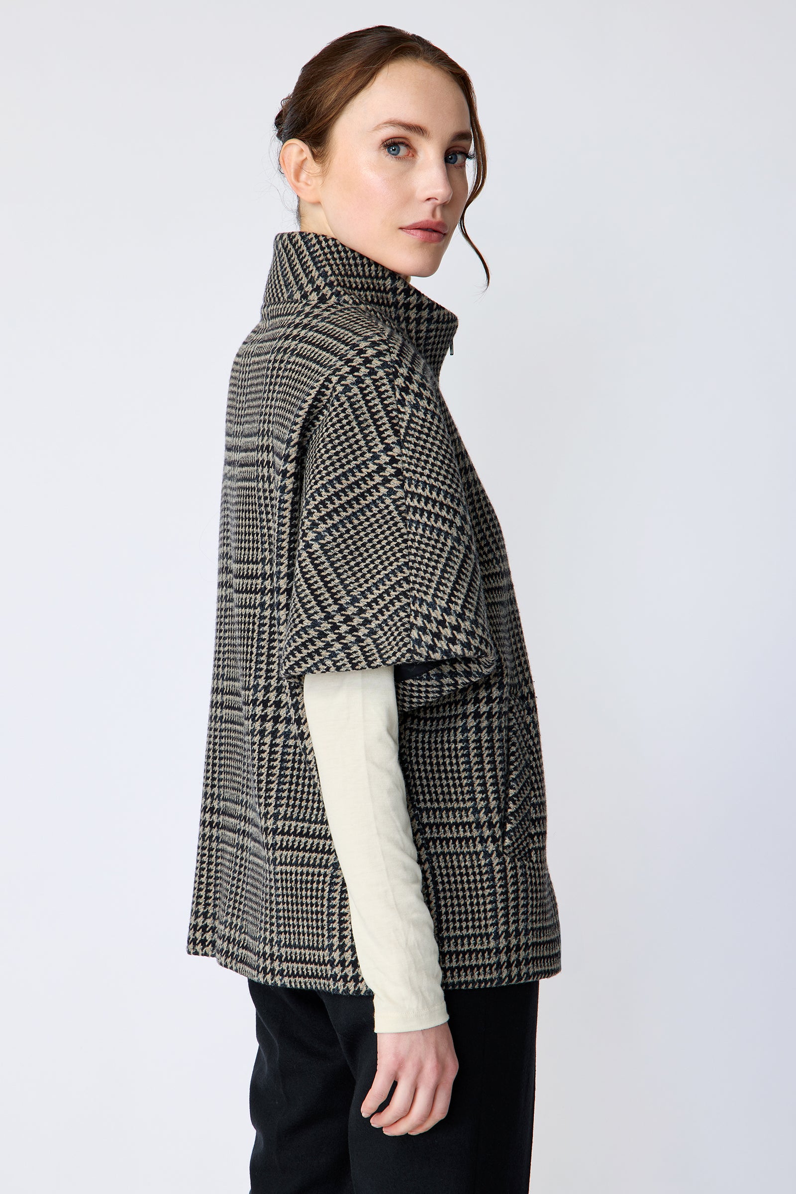 Woman wearing the Kal Rieman London Zip Vest in Multi Plaid and black pants, arms on the side, side view