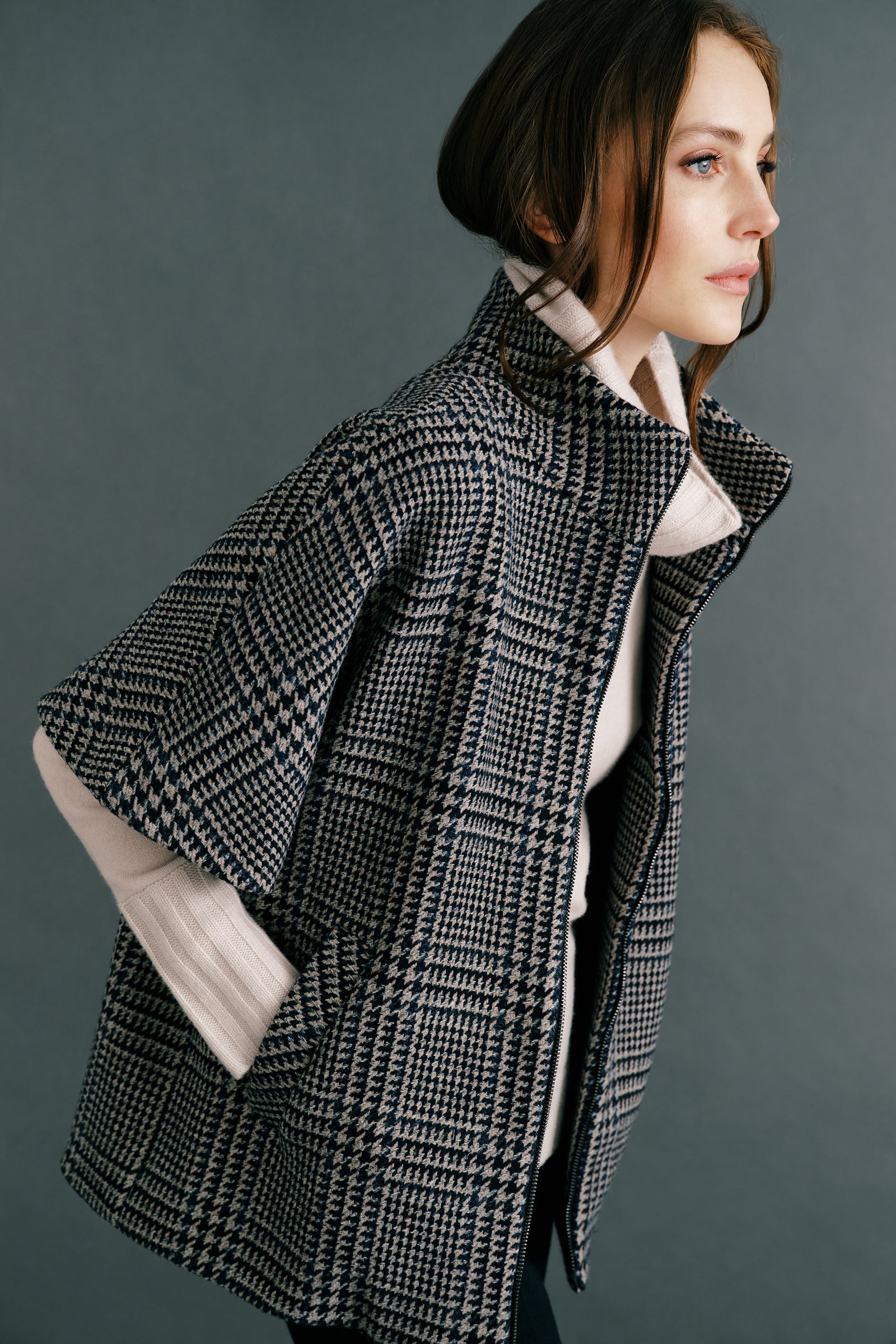 Woman wearing the Kal Rieman London Zip Vest in Multi Plaid and black pants, hands in pockets, close view