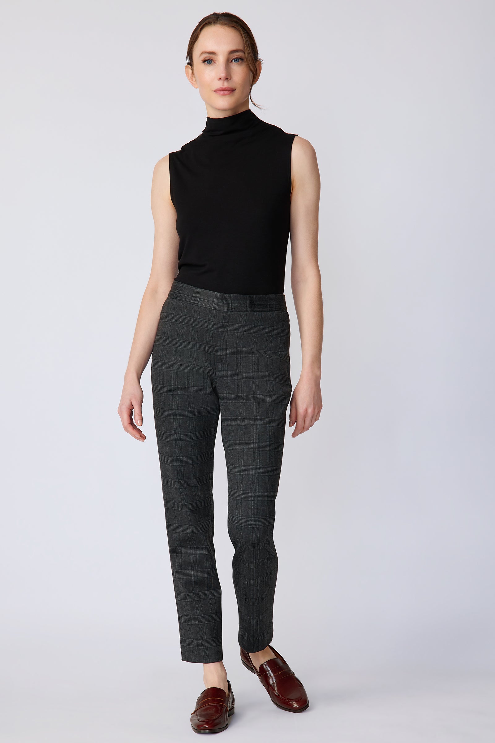 Woman wearing Kal Rieman Madison Pant in Black Glen Plaid and a black tank, arms on the side, walking