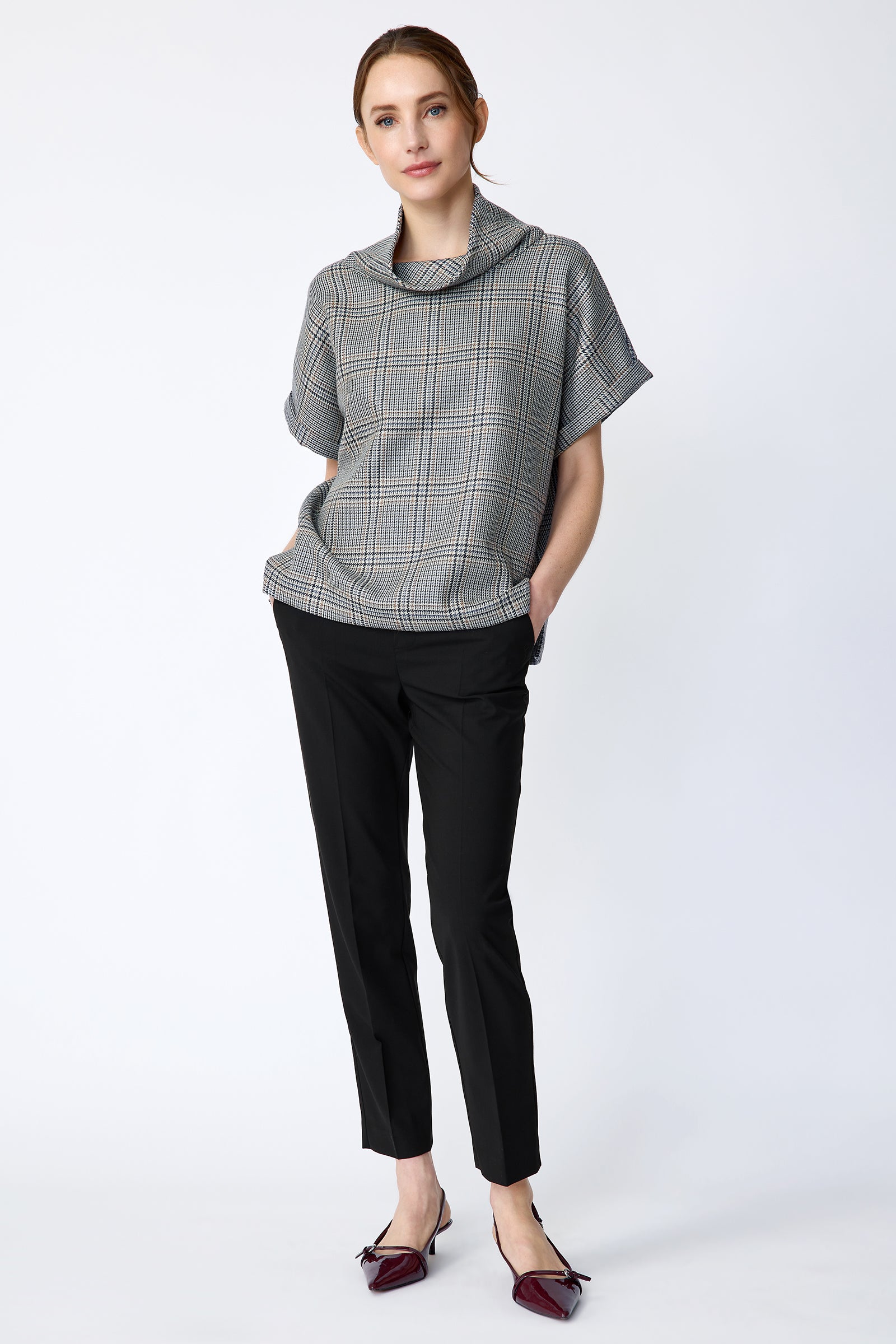 Woman wearing Kal Rieman Marin Top in Glen Plaid and black pants on a white background, hands in pant pockets