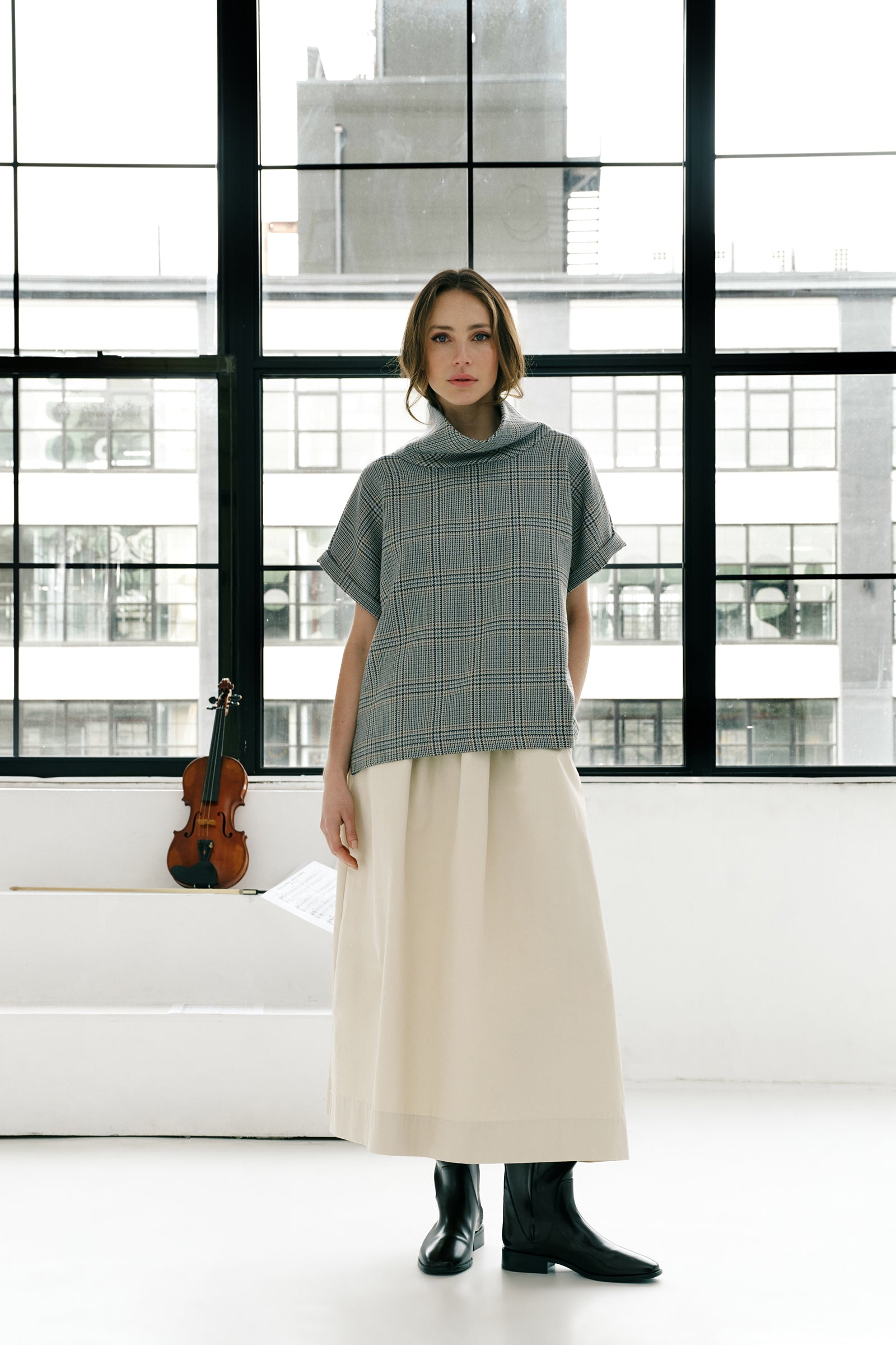 Woman wearing Kal Rieman Marin Top in Glen Plaid and black pants on a white background, hand in pant pocket close view