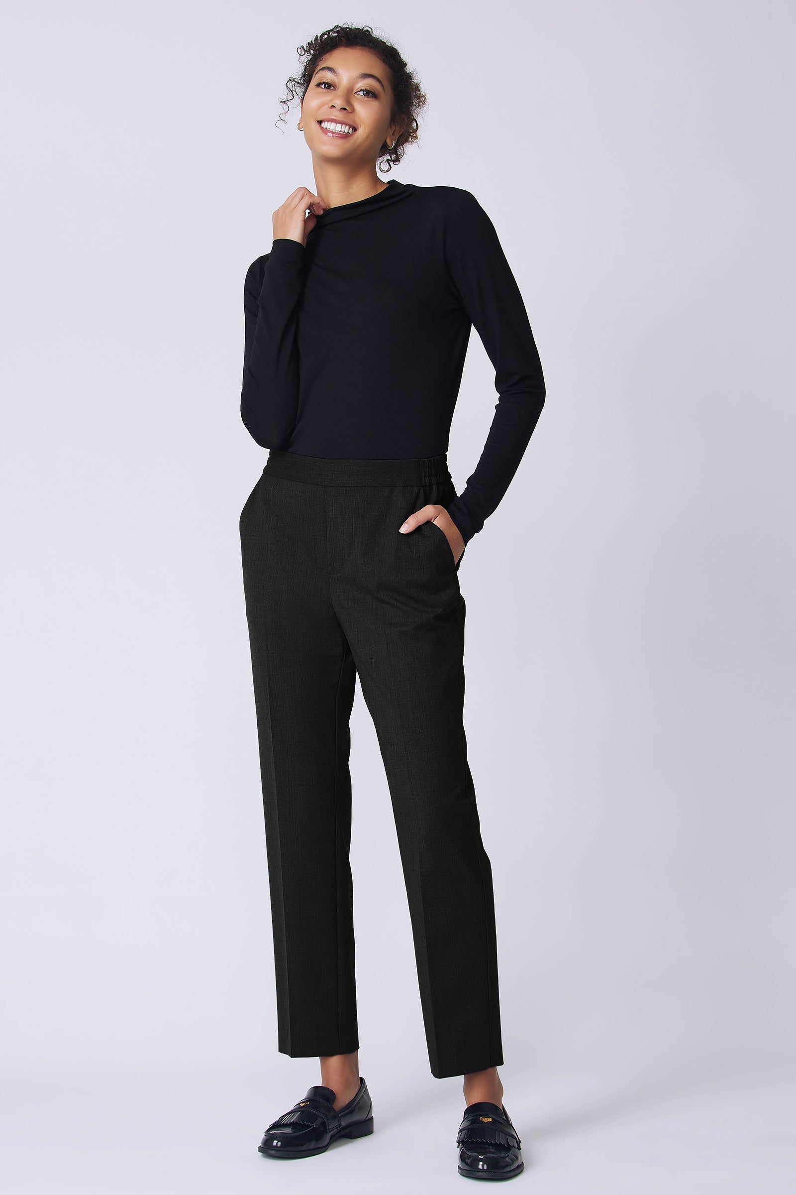 Kal Rieman Martine Trouser in Black wool suiting on model front view holding shirt collar