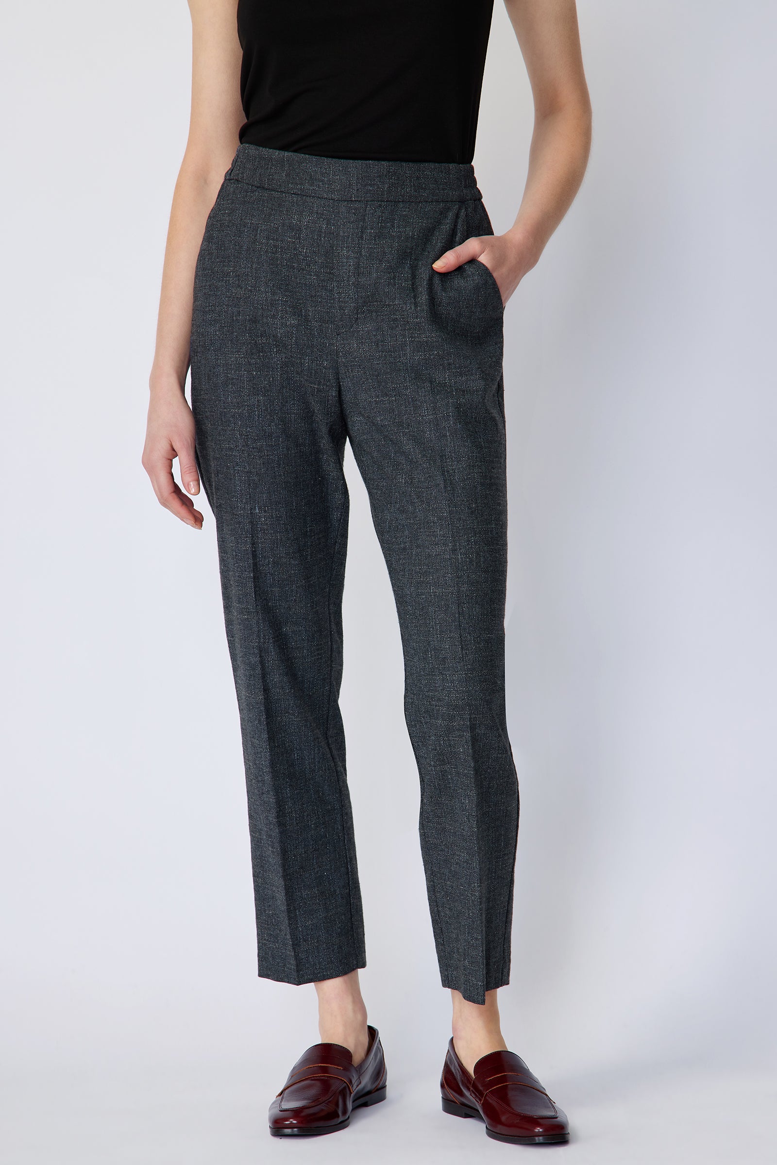 Woman wearing Kal Rieman Martine Trouser in Indigo with brown shoes, hand in pant pocket, arm on side on white background, close view