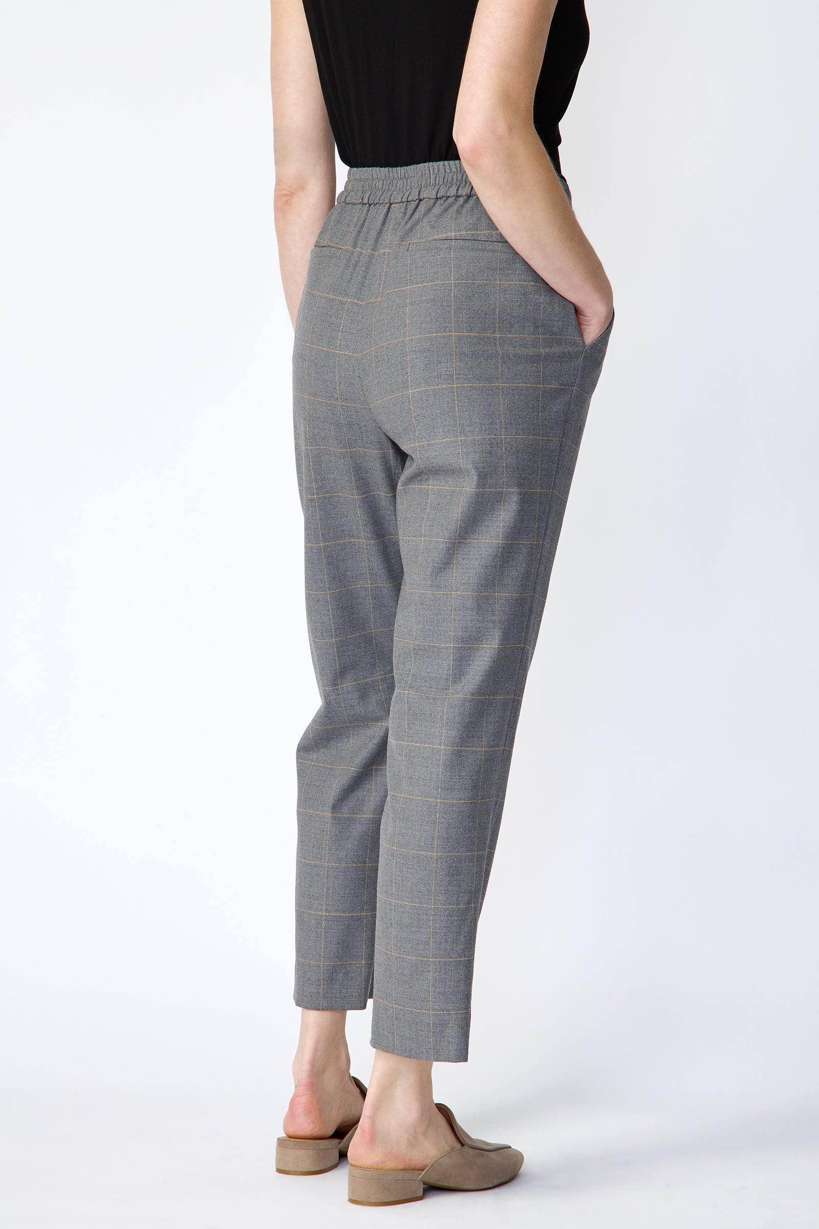 Woman wearing Kal Rieman Martine Trouser in Italian Windowpane and a black tank with brown shoes, hand in pant pocket, arm on the side, full image