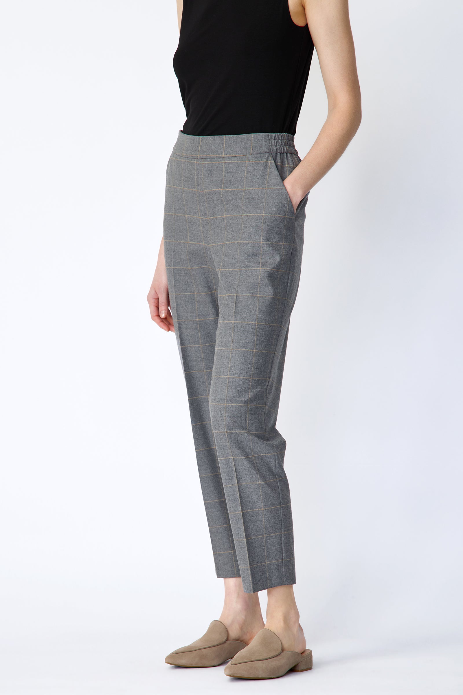 Woman wearing Kal Rieman Martine Trouser in Italian Windowpane and a black tank with brown shoes, hand in pant pocket, arm on the side, side view