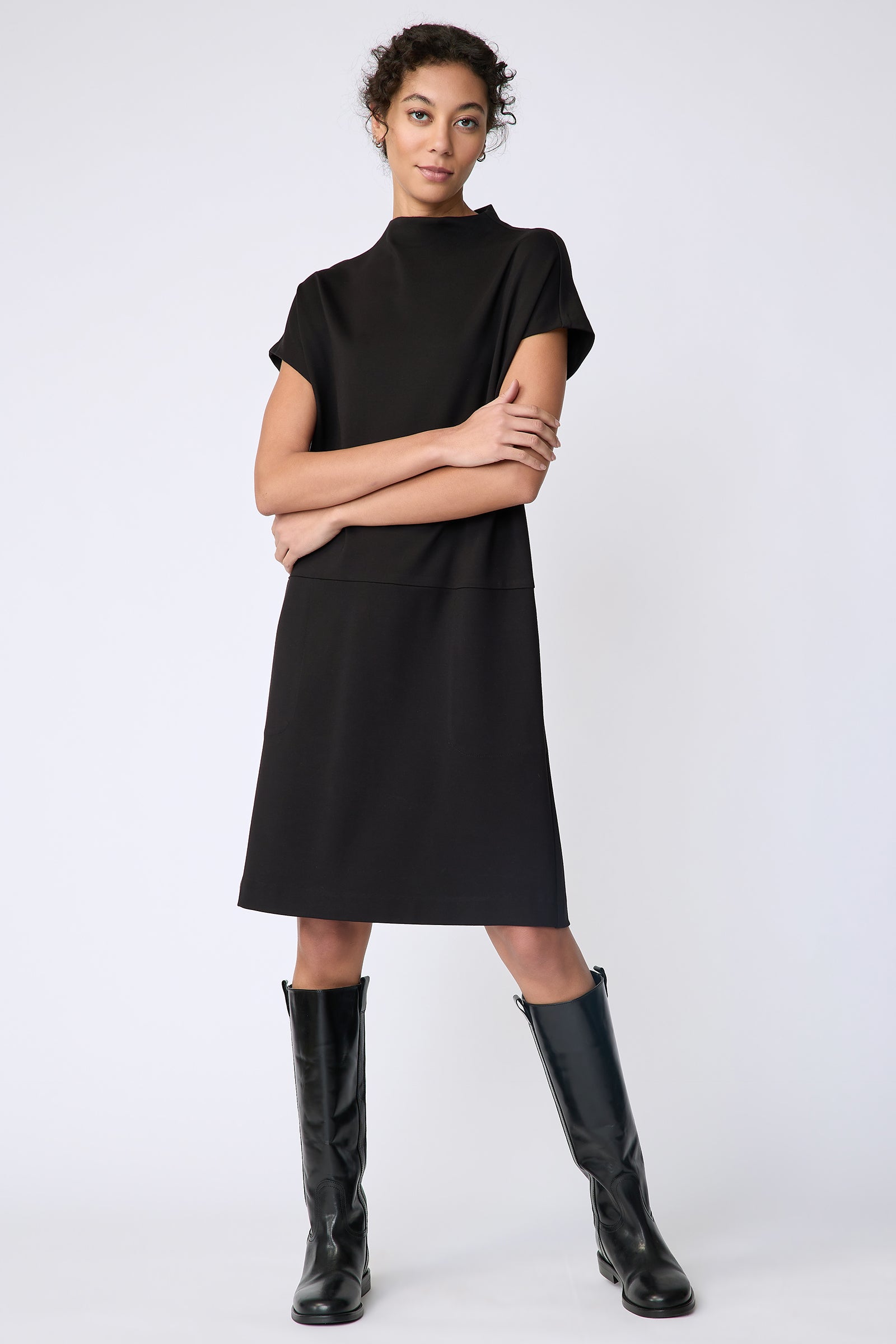 Kal Rieman Maya Funnelneck dress in black ponte on model front view arms crossed in front