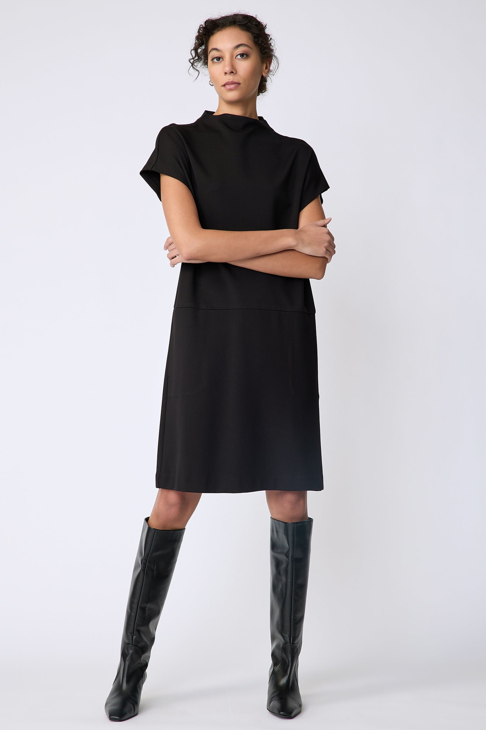 Kal Rieman Maya Funnelneck dress in black ponte on model front view arms crossed in front