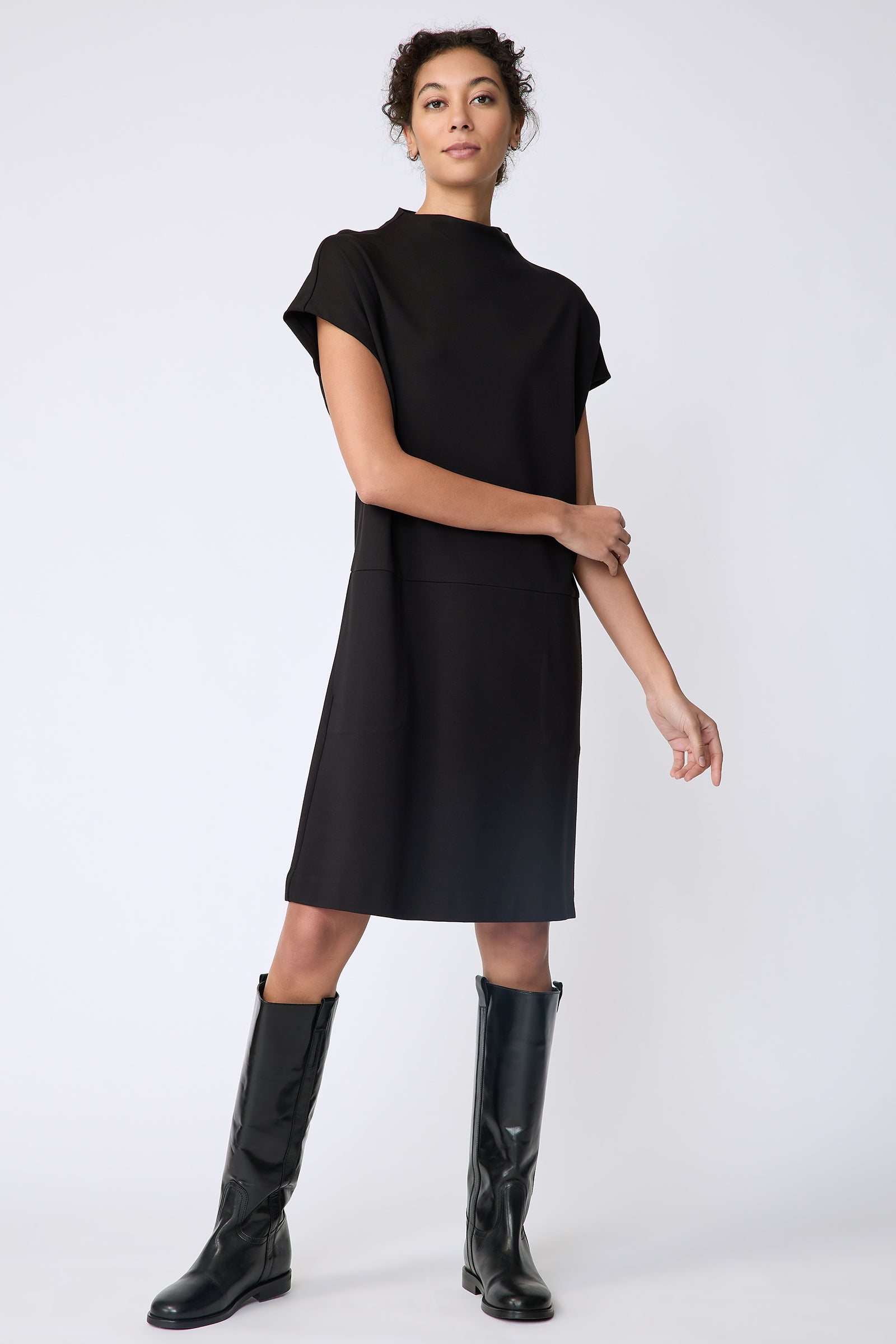 Kal Rieman Maya Funnelneck dress in black ponte on model front view holding arm
