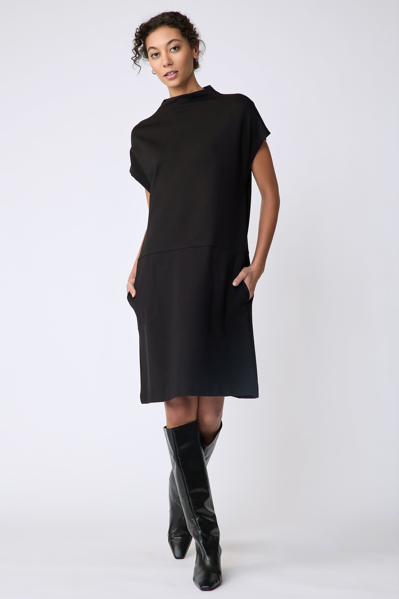 Kal Rieman Maya Funnelneck dress in black ponte on model front view walking hands in pocket