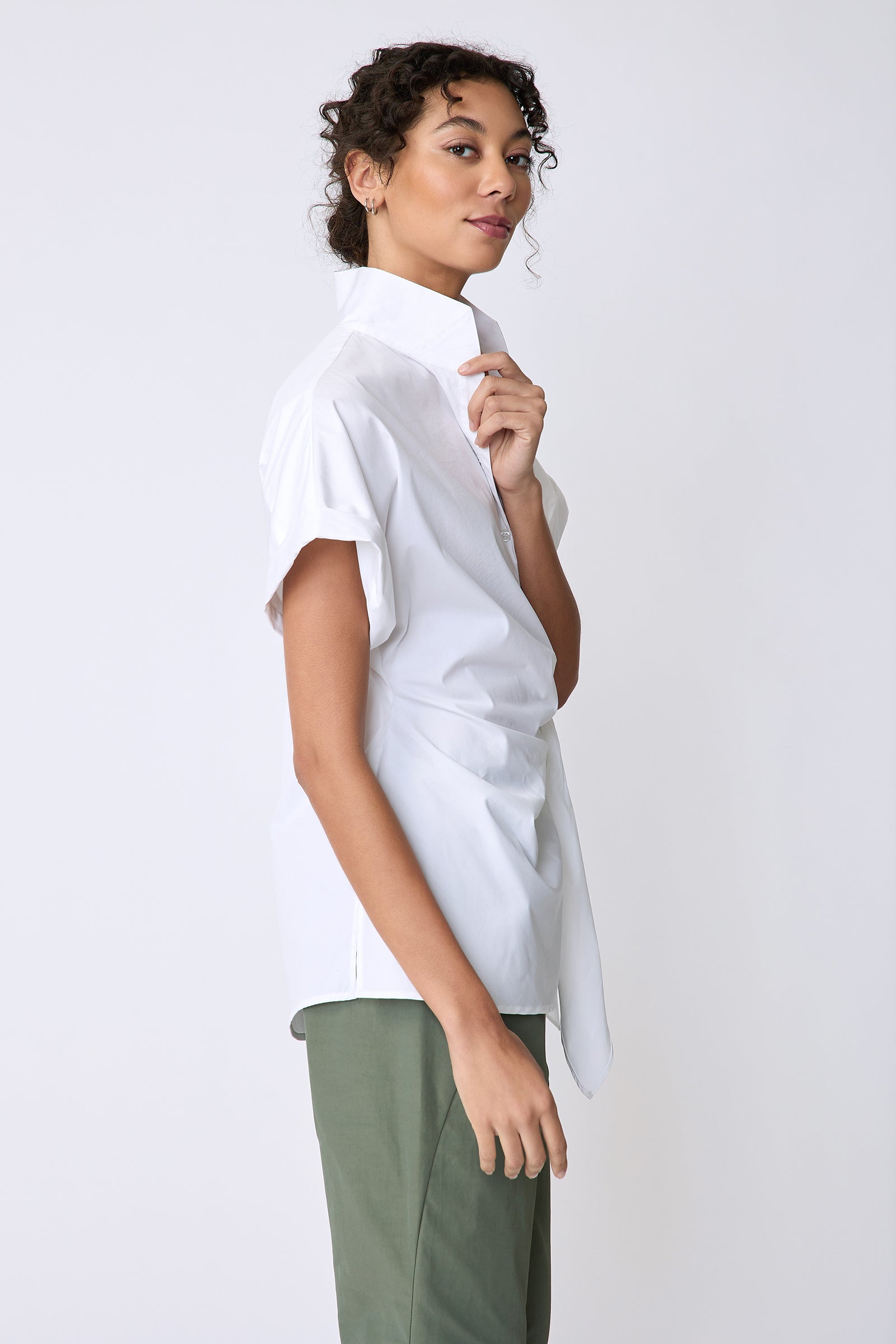 Kal Rieman Mila Wrap Top in white stretch cotton on model side view holding collar
